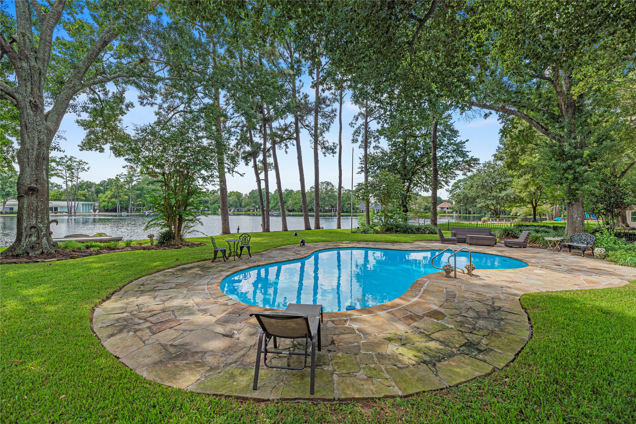 Sparkling pool, expansive patio, lush green space, and 105' of lakefront.