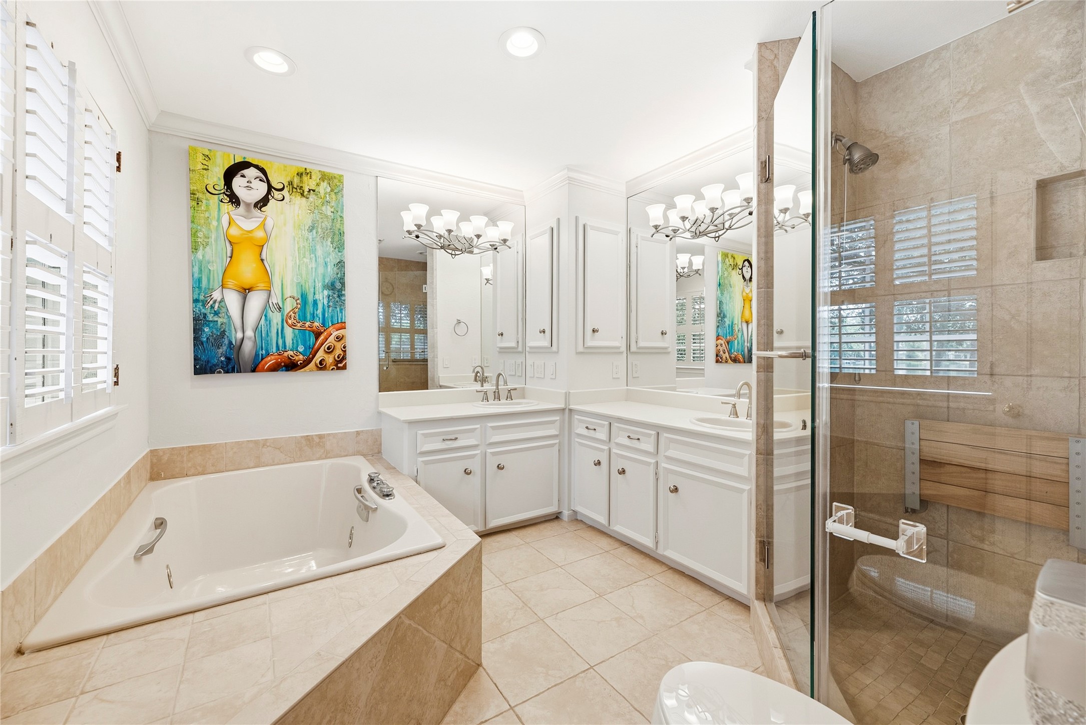 En-suite primary bath with dual sinks, large glass enclosed shower, and a soaking tub.