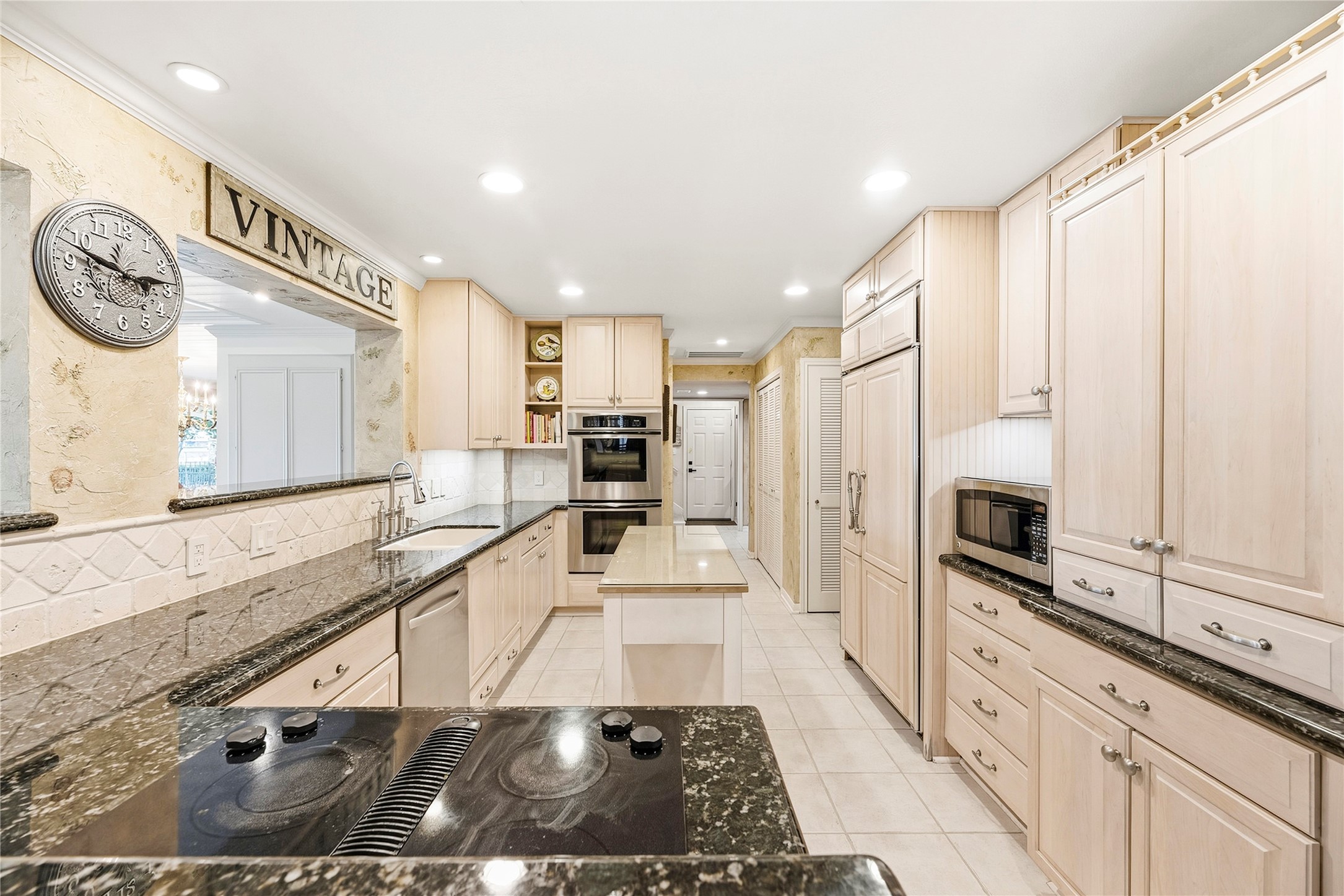 Timeless kitchen complete with granite countertops, Thermador double ovens, wood-paneled sub-zero refrigerator, recessed lights and more.