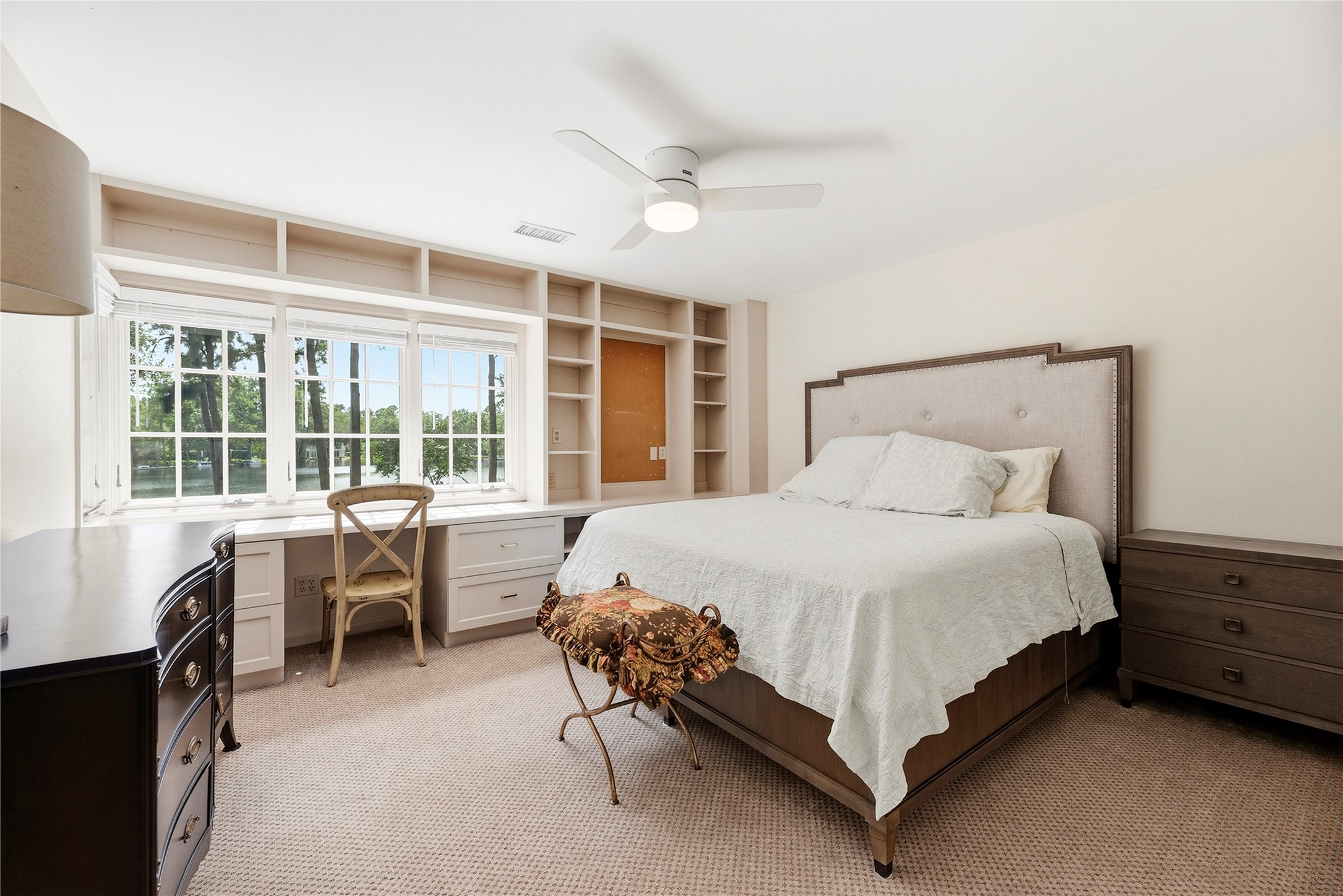 Secondary bedroom with wonderful built ins, plush carpet, and lakefront views.