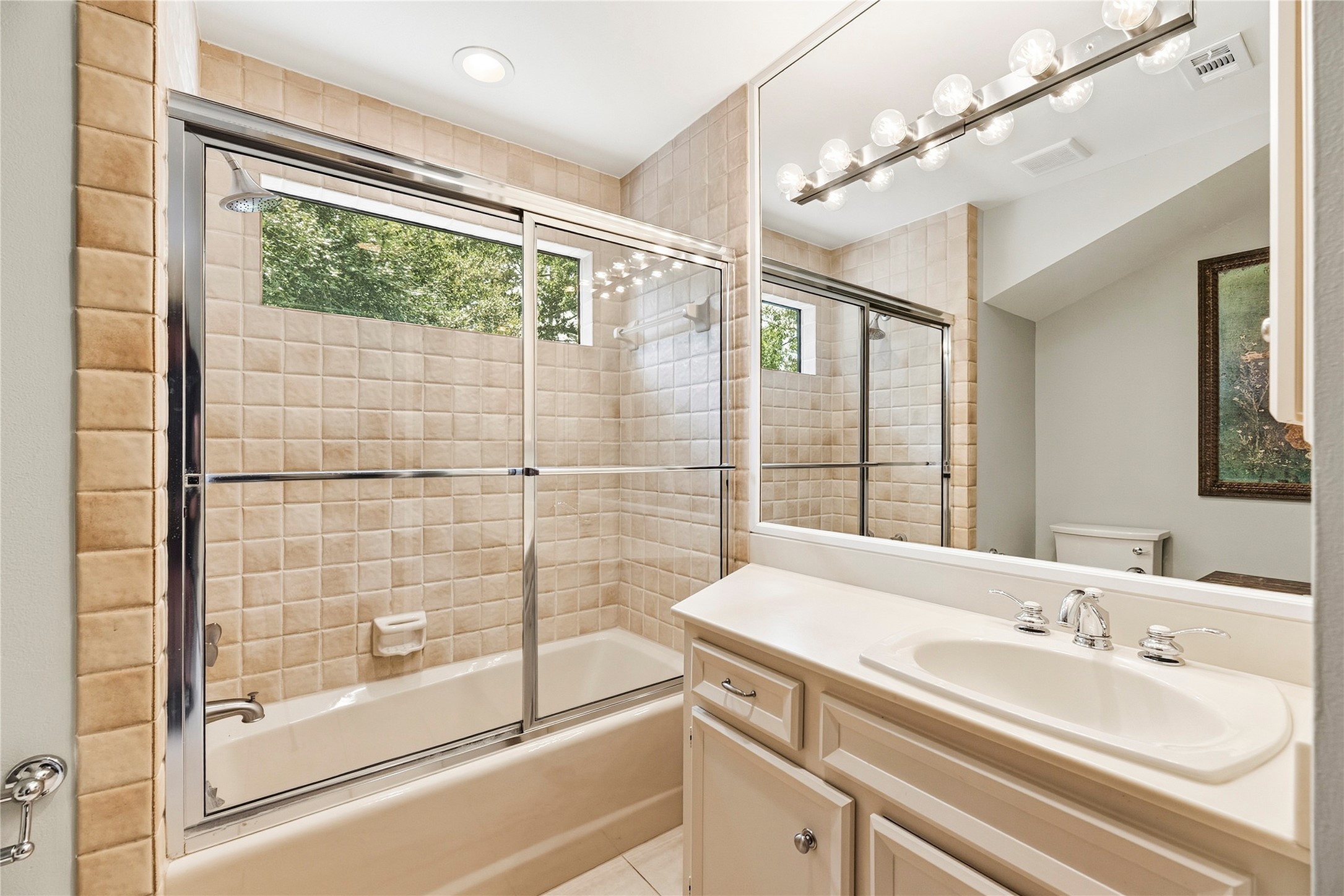 Secondary bathroom with a shower/tub combo + vanity.