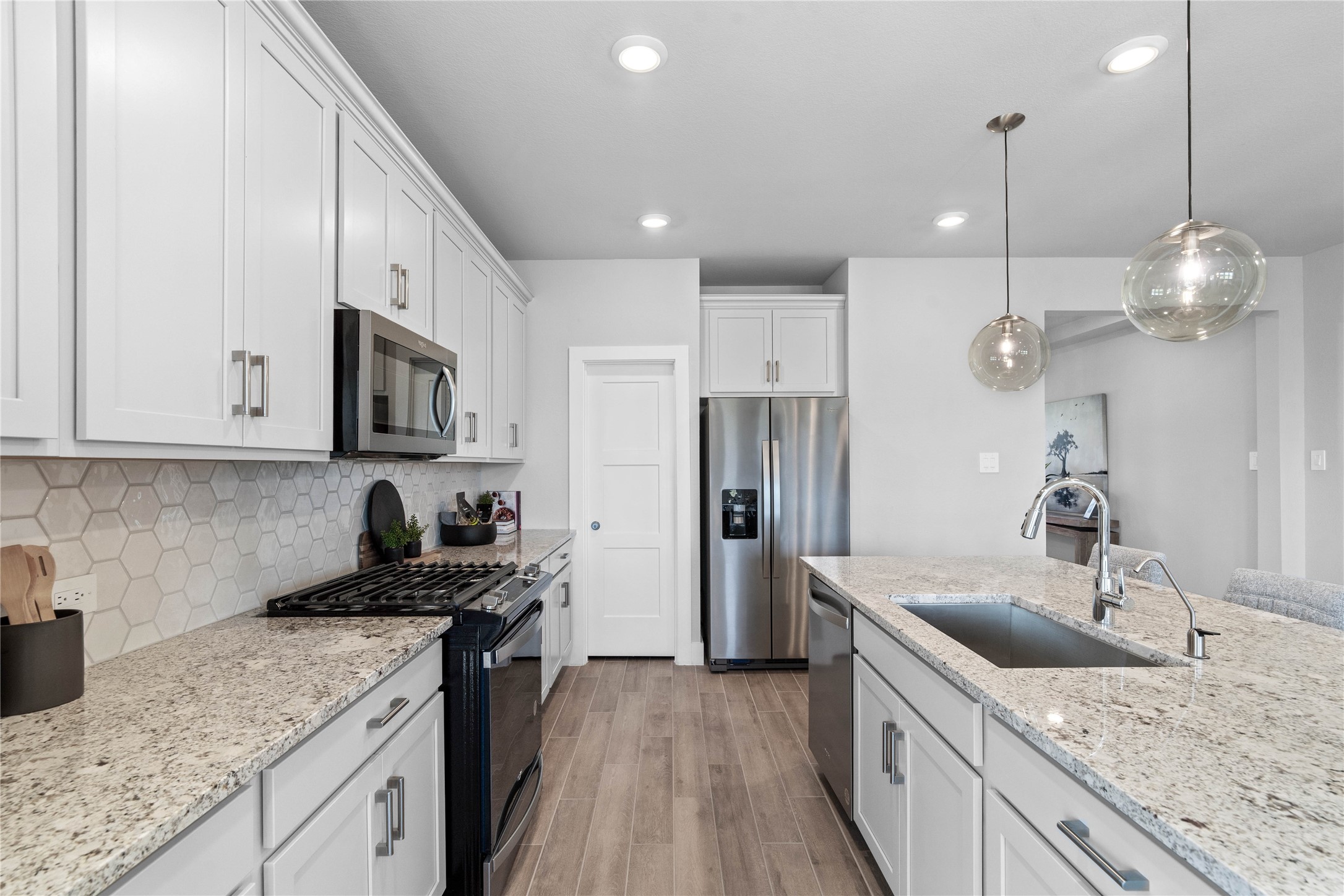 Welcome to the heart of the home, a modern, highly functional kitchen that perfectly balances style and utility. Granite countertops, complemented by a stylish backsplash, shaker-style cabinets provide ample storage, and the Whirlpool stainless steel appliances are all features of this beautiful kitchen!