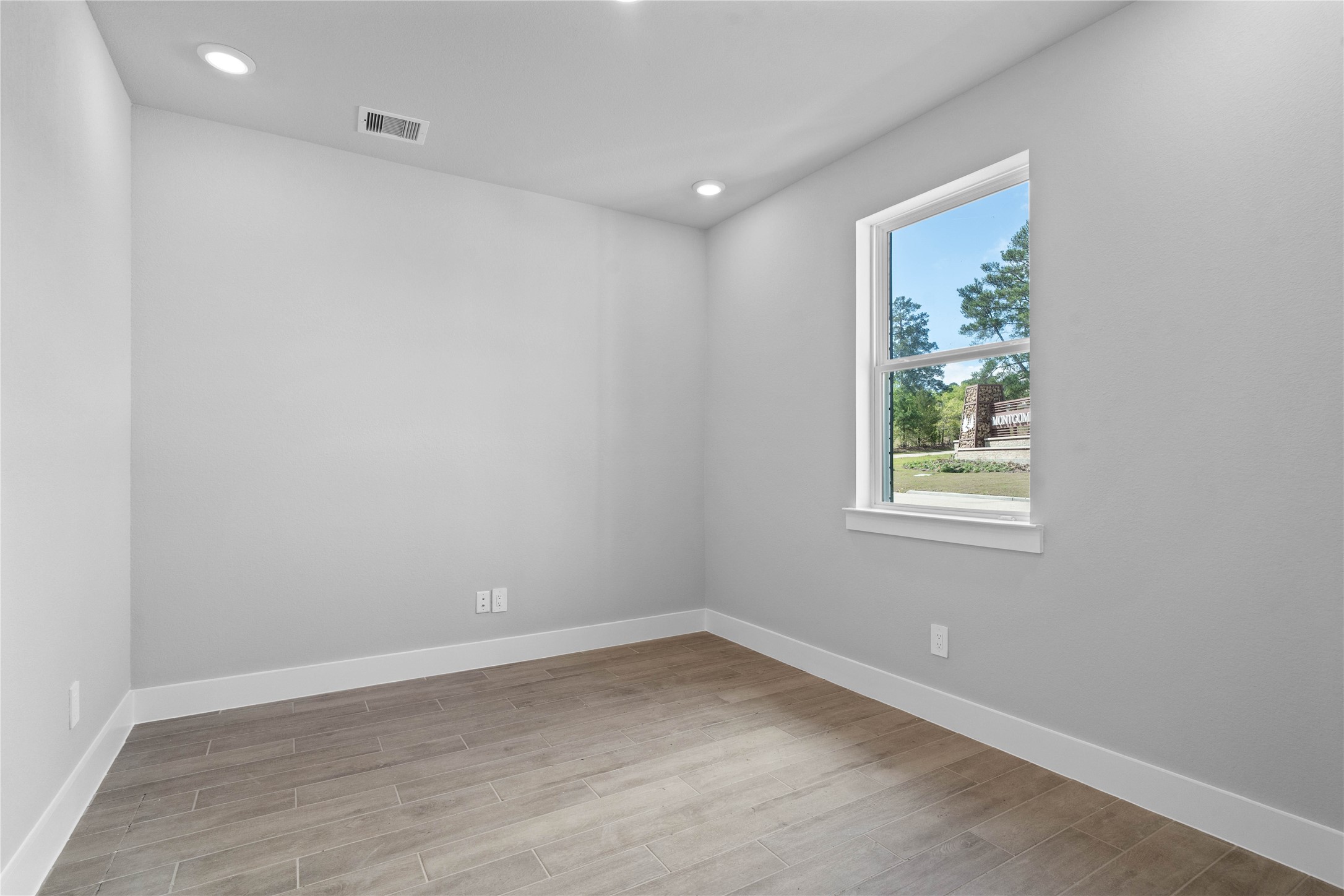 Tucked peacefully in the front of the home is this handsome Study featuring wood-look tile flooring, large window, high ceilings, recessed lighting, double doors, and custom paint!