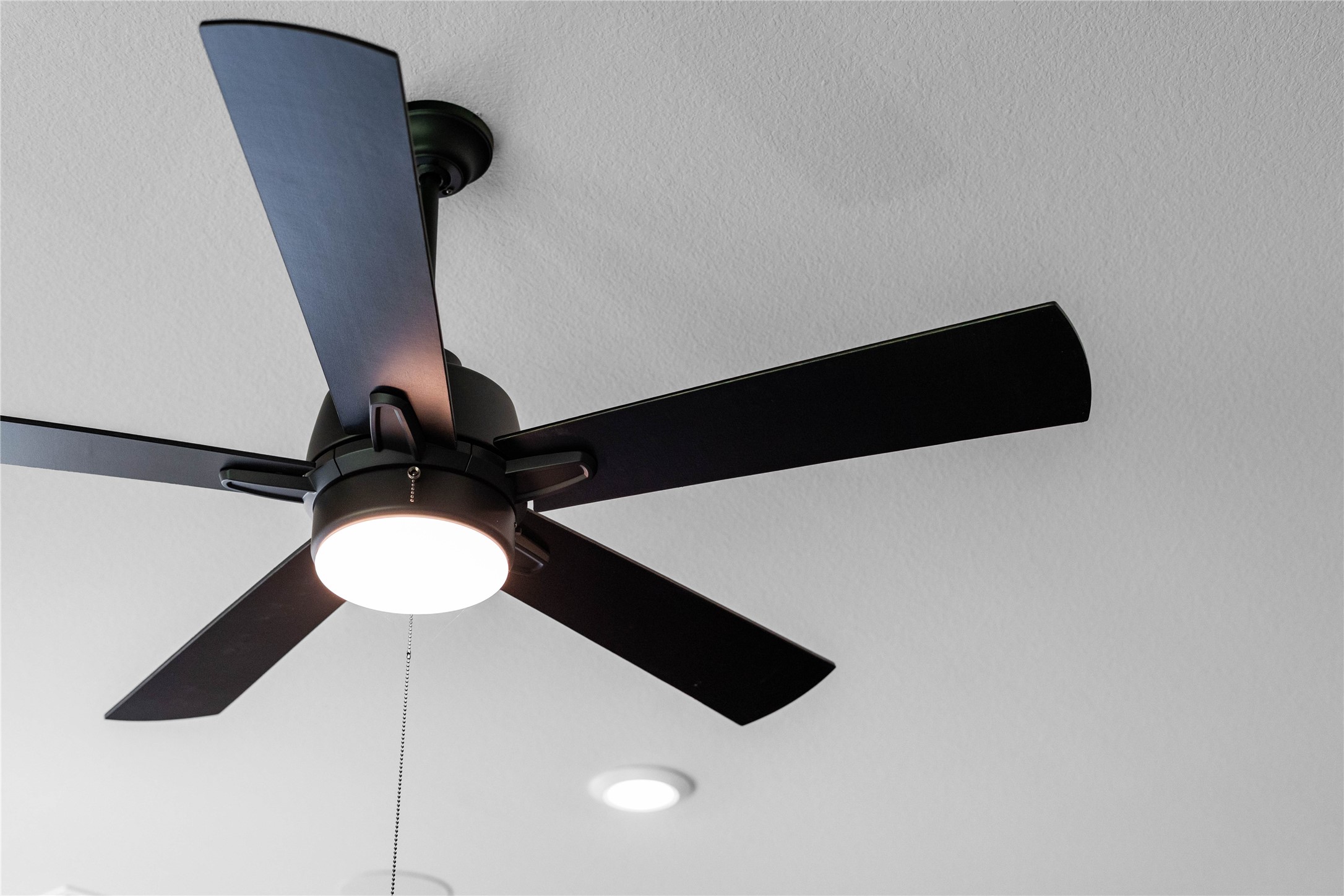This contemporary ceiling fan features five dark wood blades, centered by an integrated LED light kit and a traditional pull chain for effortless control. The ceiling fan will make a room feel up to 48 degrees cooler and redistribute rising warm air in the winter.