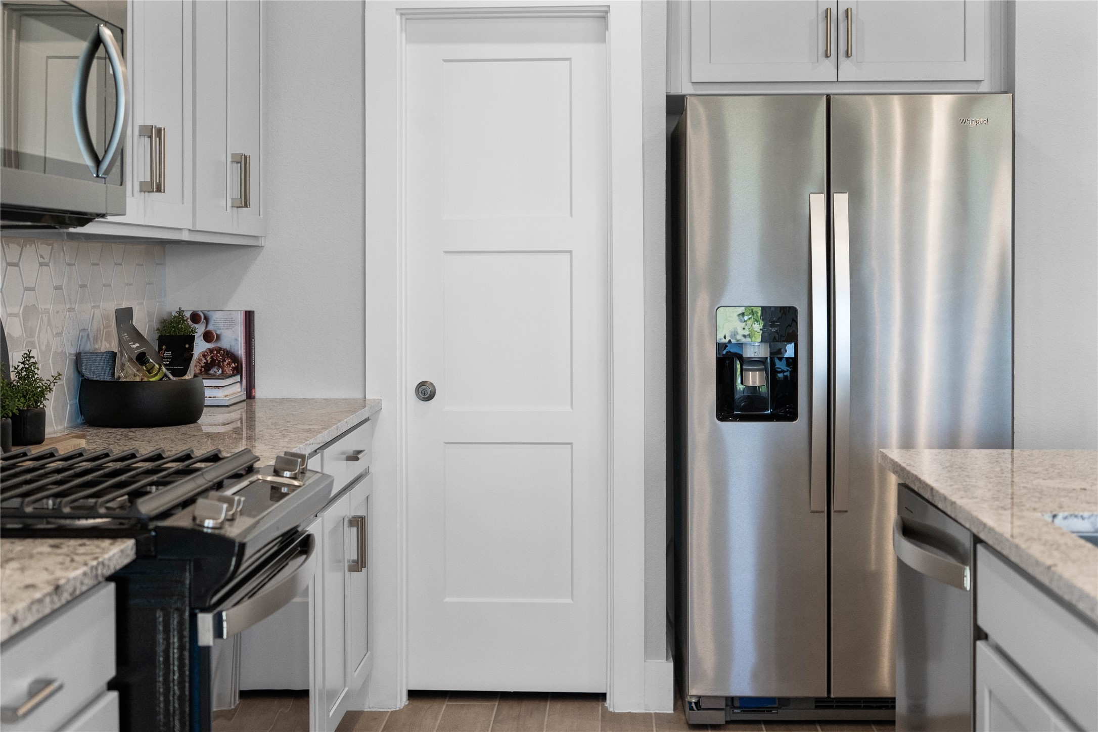 Kitchen comes equipped with a side-by-side Whirlpool refrigerator.