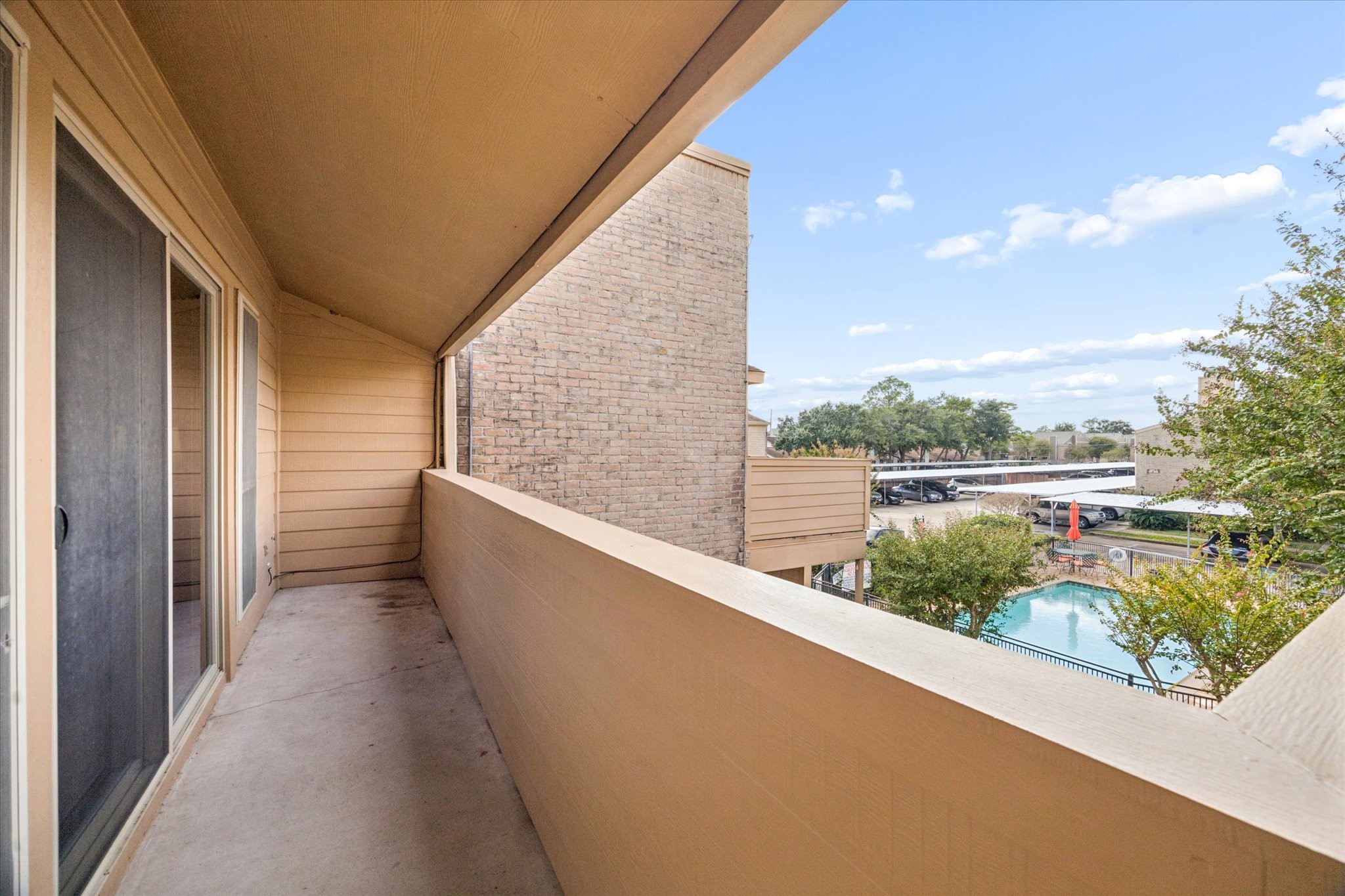 Private covered patio overlooking the community pool, offering a relaxing outdoor space just steps from the unit.
