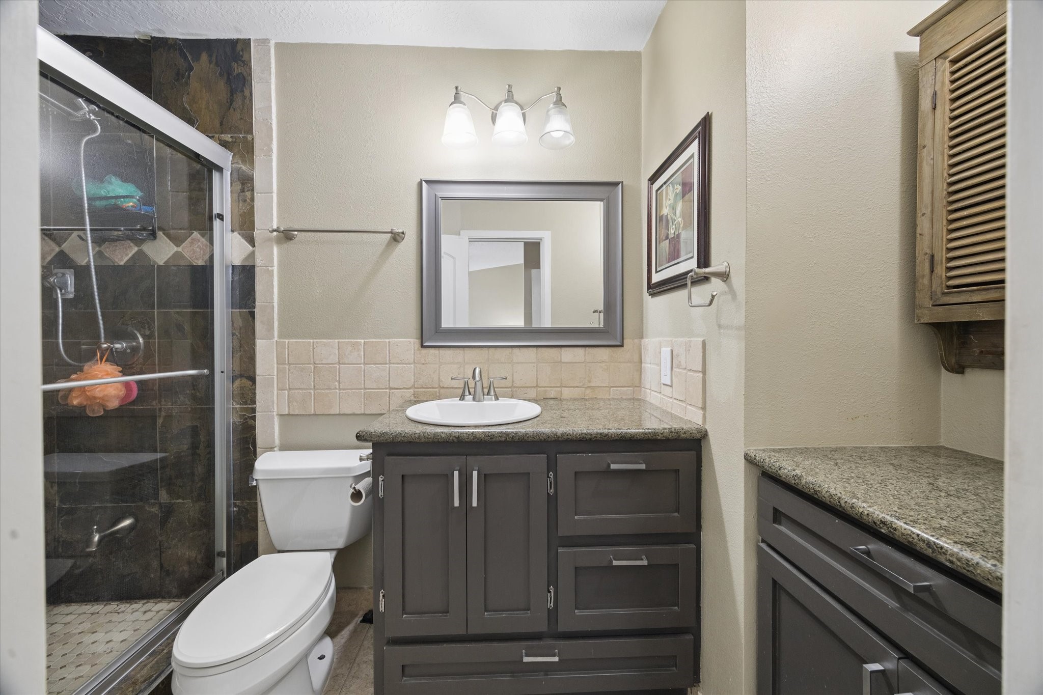 Updated bathroom featuring a walk-in shower with glass enclosure, modern vanity, tile flooring, and a clean, neutral finish. Updated bathroom featuring a walk-in shower with glass enclosure, modern vanity, tile flooring, and a clean, neutral finish.