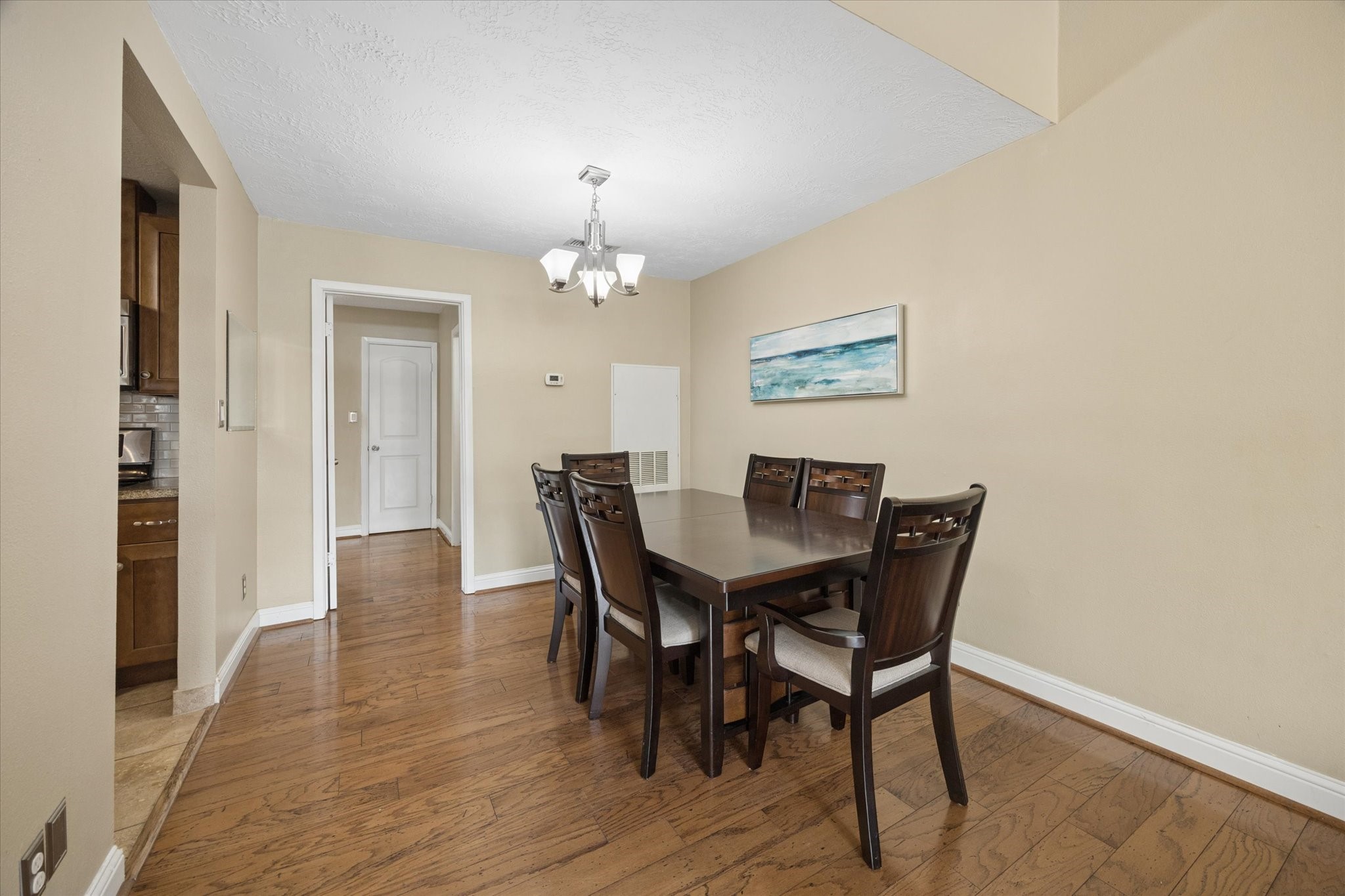 Dining area with hardwood floors, neutral finishes, and a clean, open feel, conveniently positioned between the kitchen and living spaces. Dining area with hardwood floors, neutral finishes, and a clean, open feel, conveniently positioned between the kitchen and living spaces.