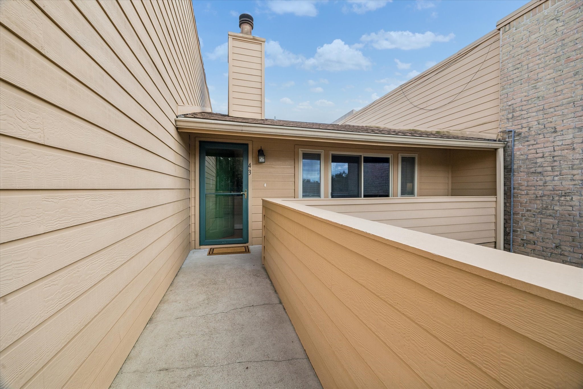 Exterior walkway leading to the unit, offering a private approach with an open-air setting and easy access to the second-floor residence.