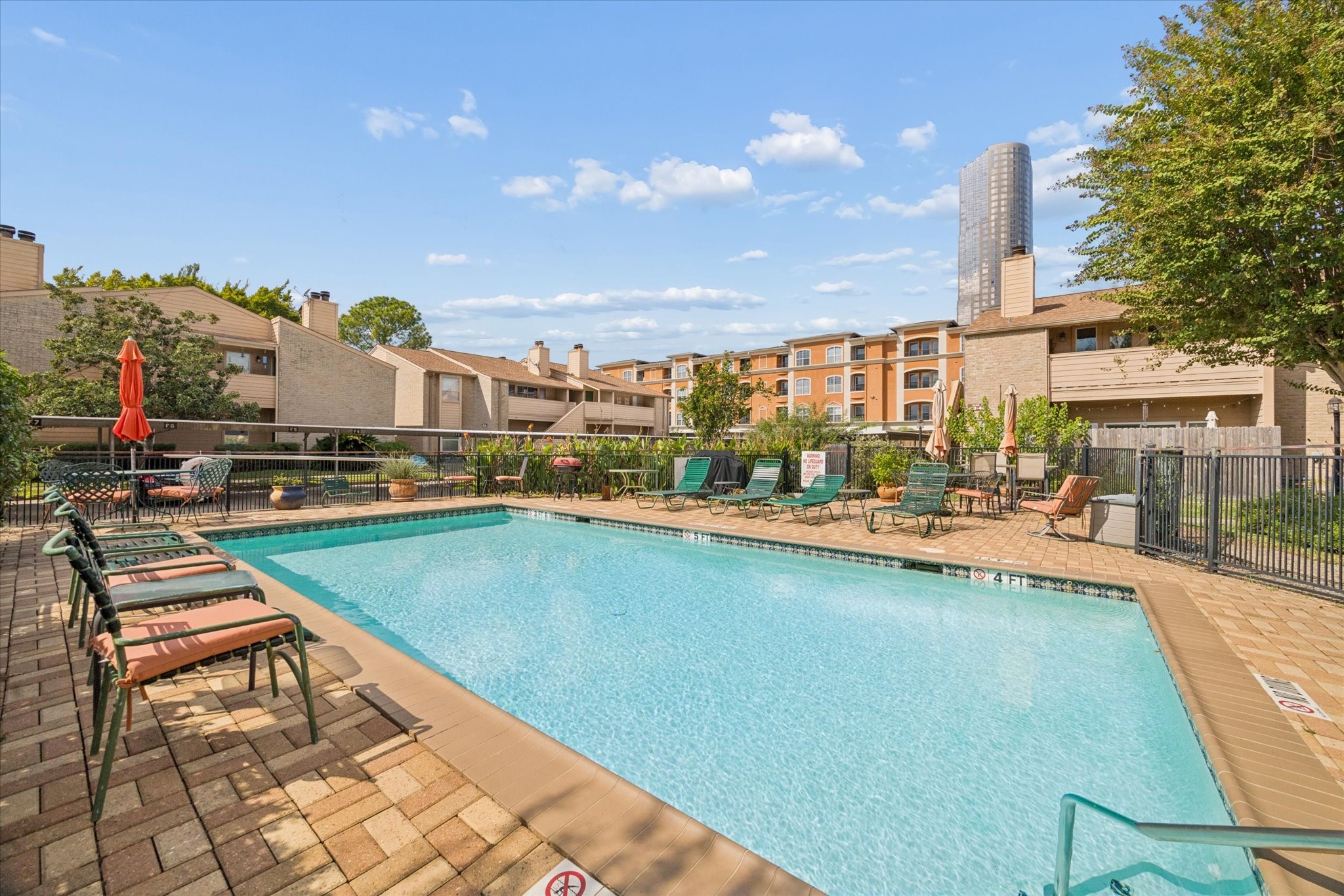 Resort-style community pool surrounded by landscaped grounds and ample lounging space, offering a relaxing retreat just steps from the unit.