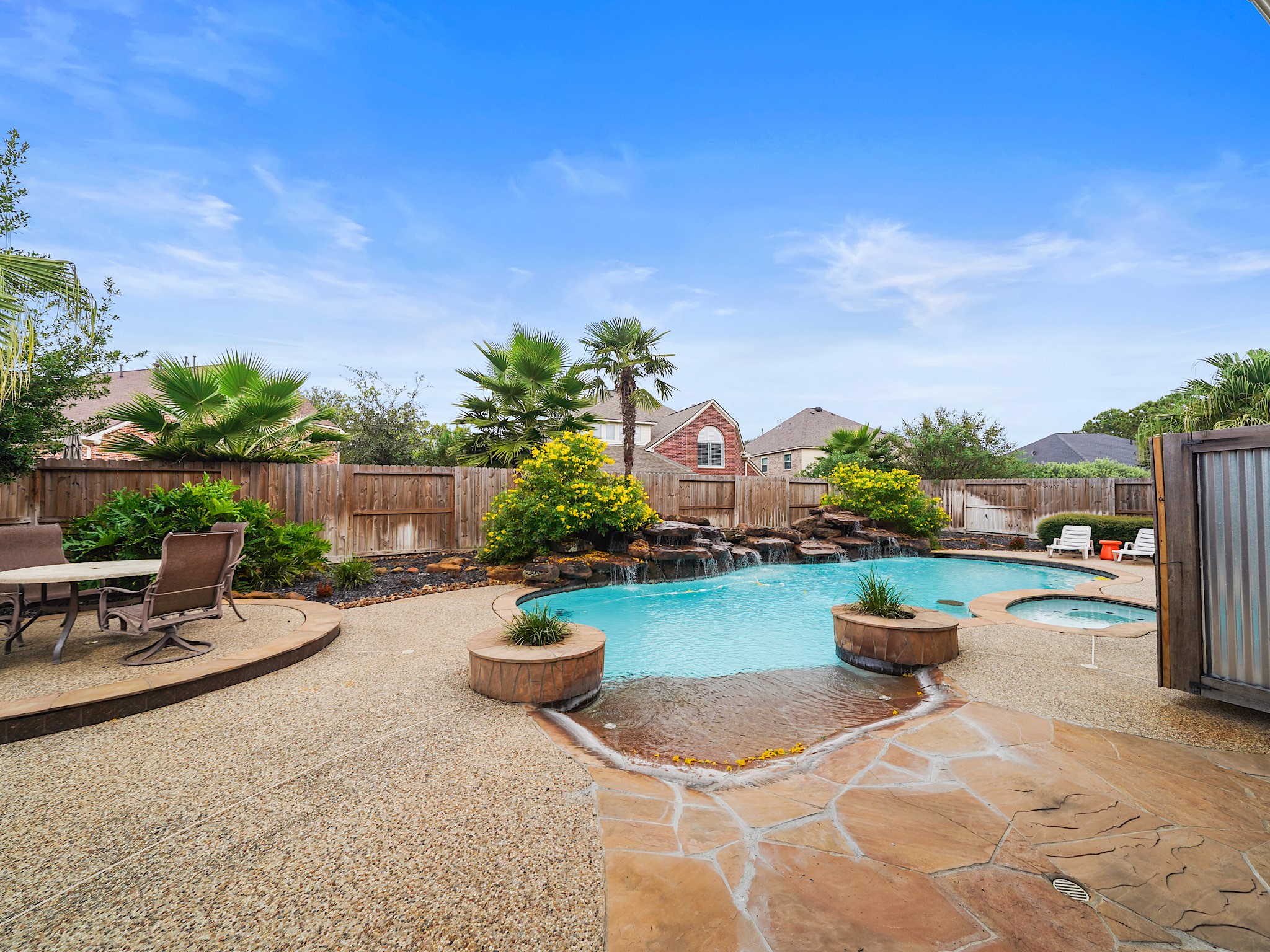 Wide patio surrounds and a sculpted pool-and-spa design make this backyard ready for lounging, play, and gathering under the open sky.
