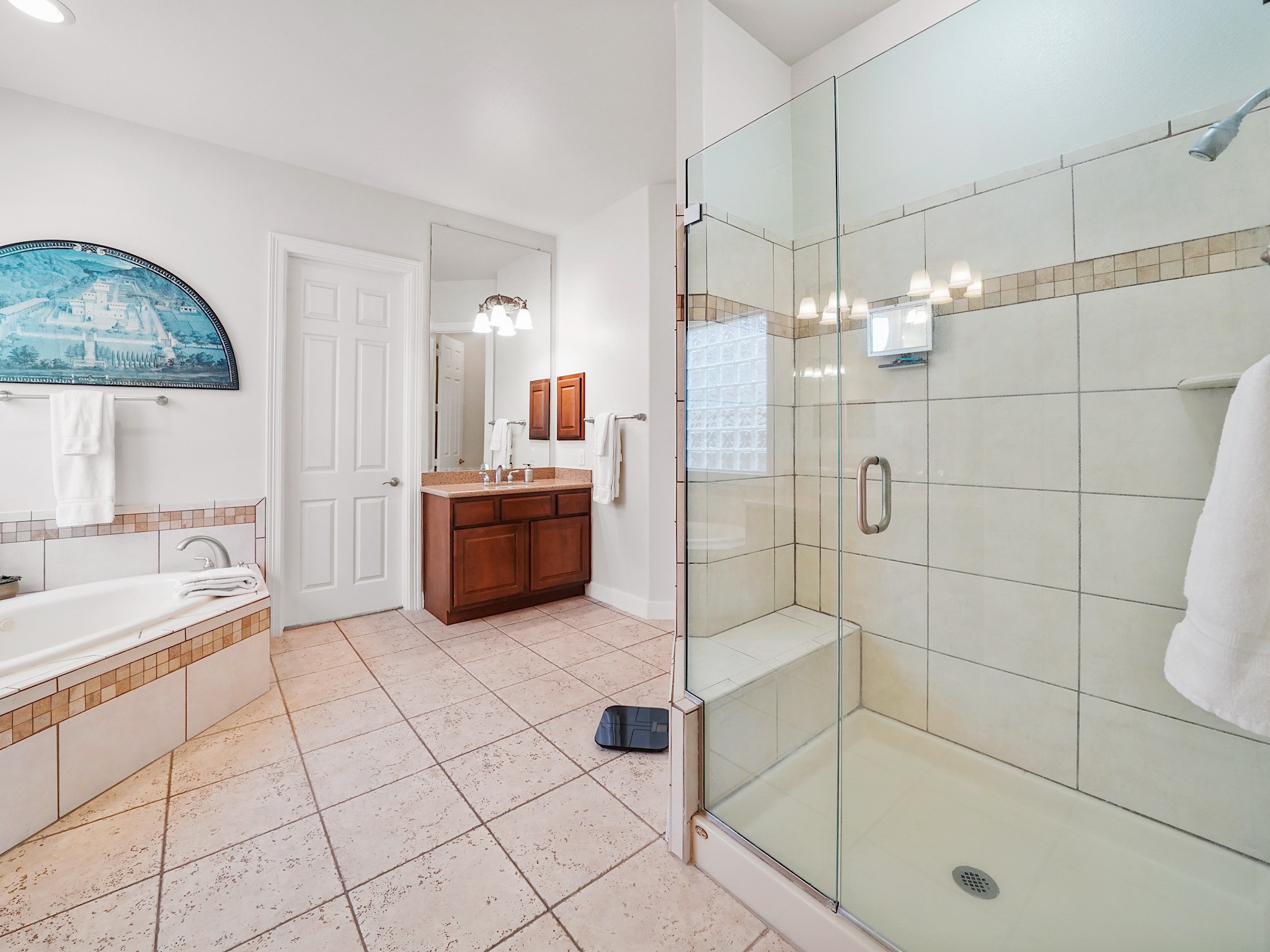 Designed for a spa-like reset, the primary bath pairs a glass-enclosed shower with a spacious, light-filled layout.