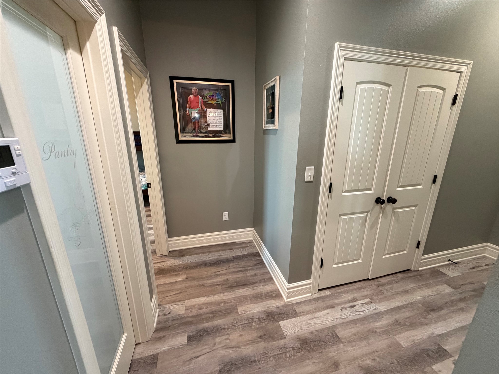 Hallway with pantry on the left and laundry closet on the right