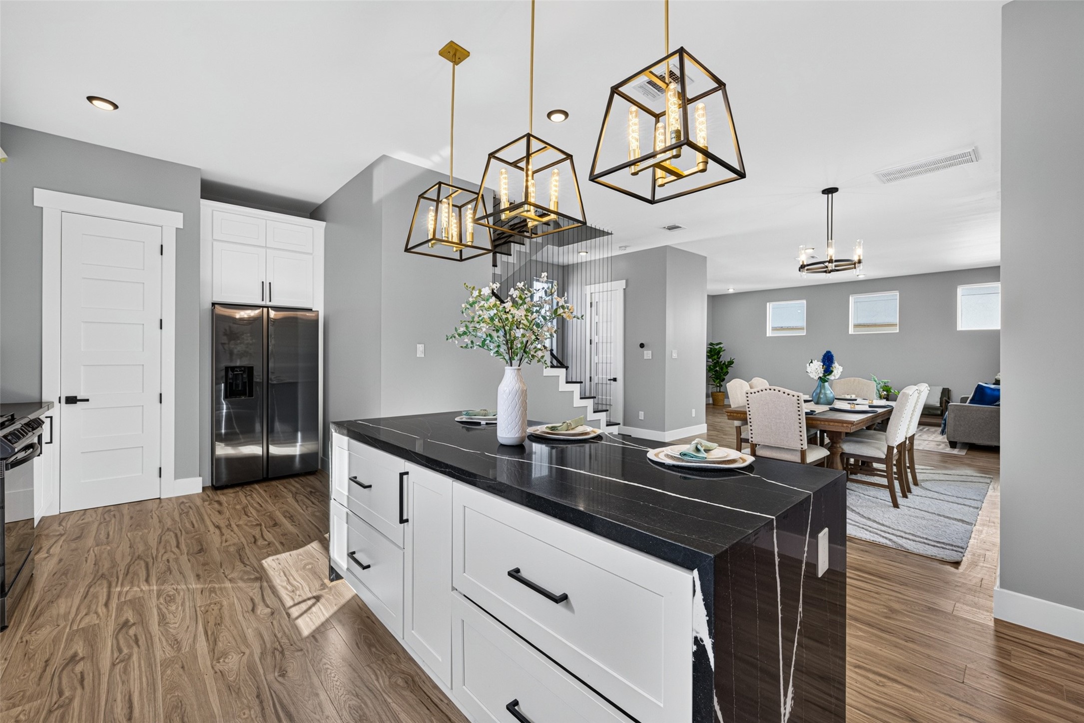 Chic pendant lighting overhead casts a cozy glow across the open space, keeping you connected to the surrounding living and dining areas.