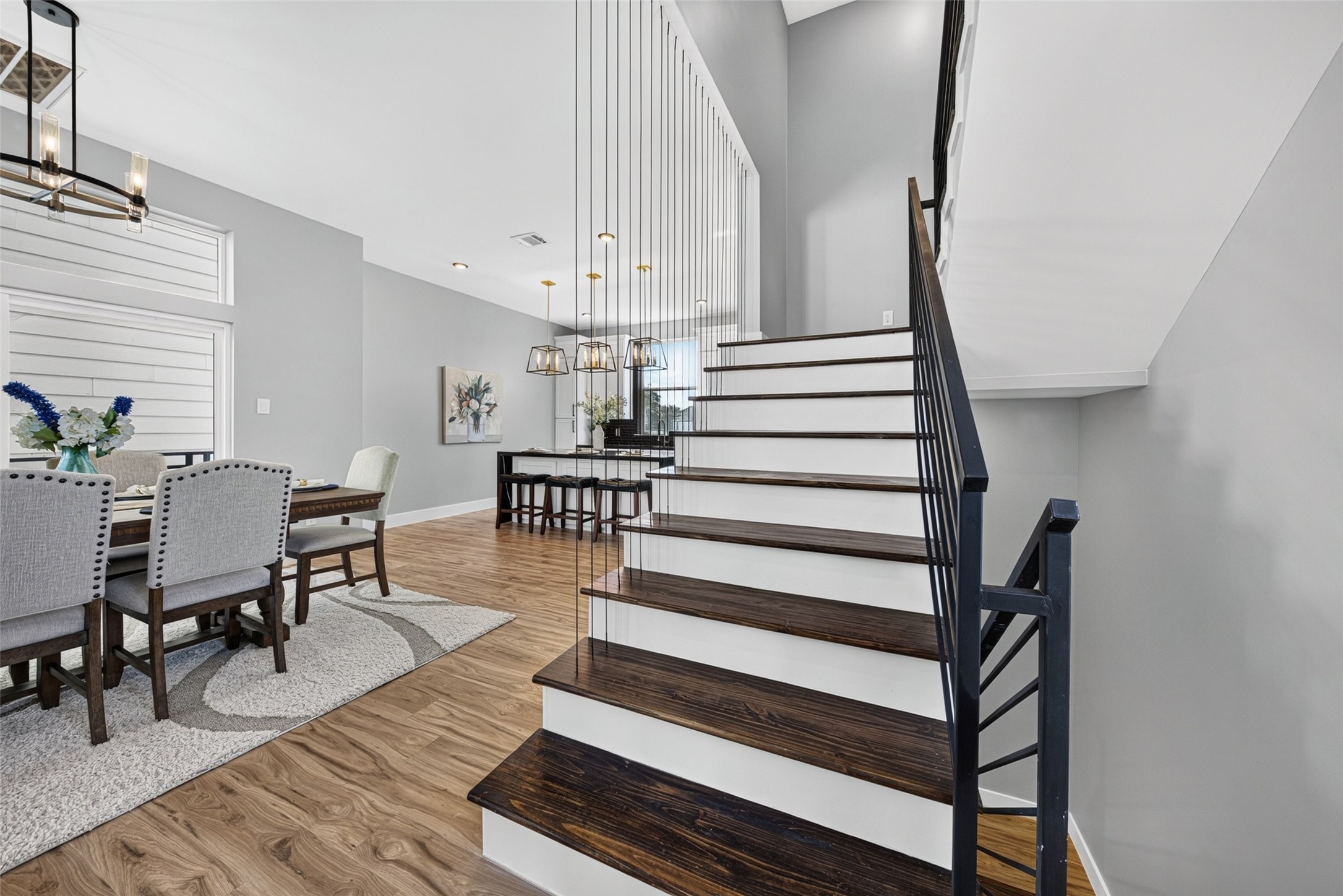View of the dining area and staircase leading up to the third-level private bedrooms.