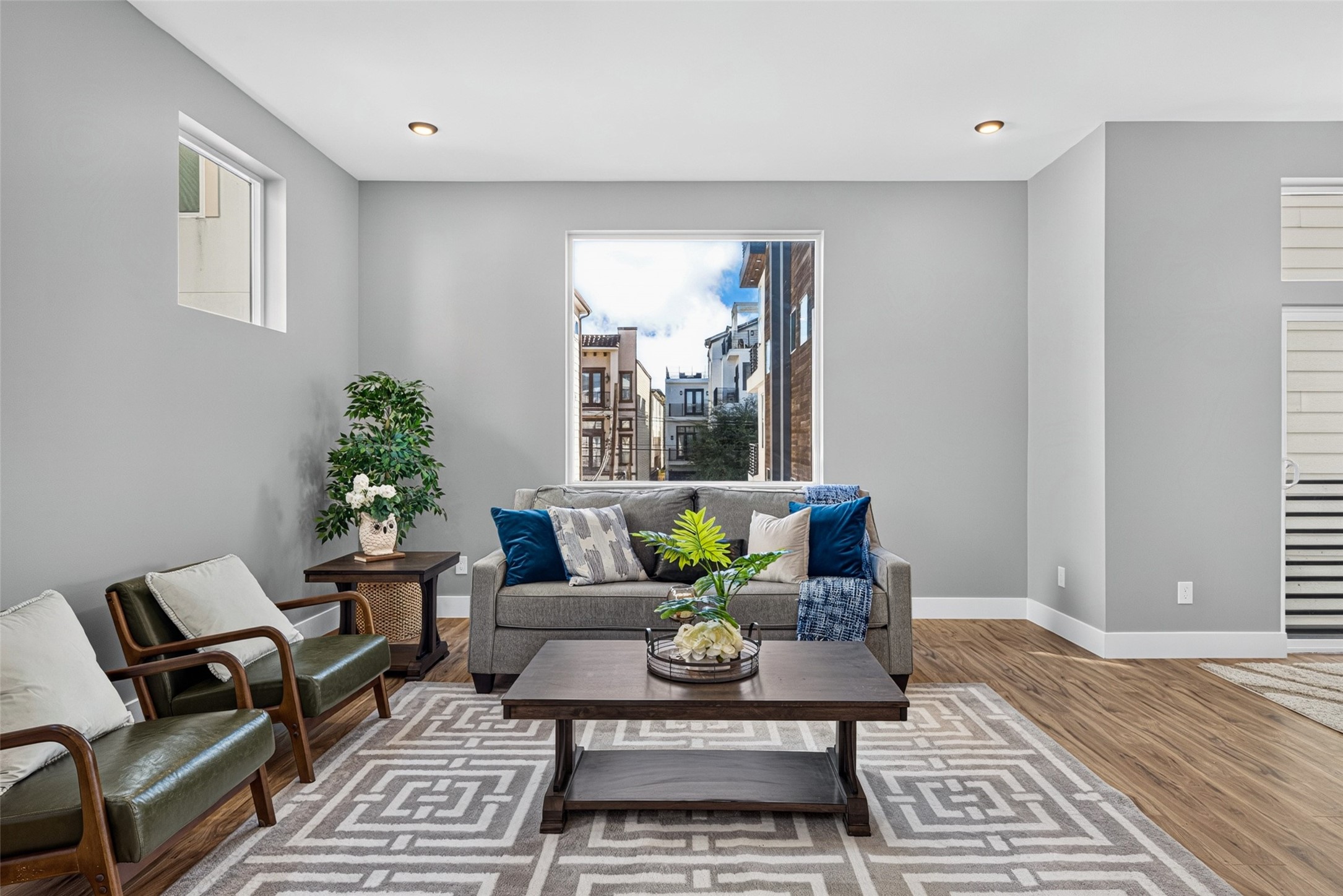 Beautiful hardwood floors and large windows fill the space with warmth and natural light, creating a cozy, inviting atmosphere.