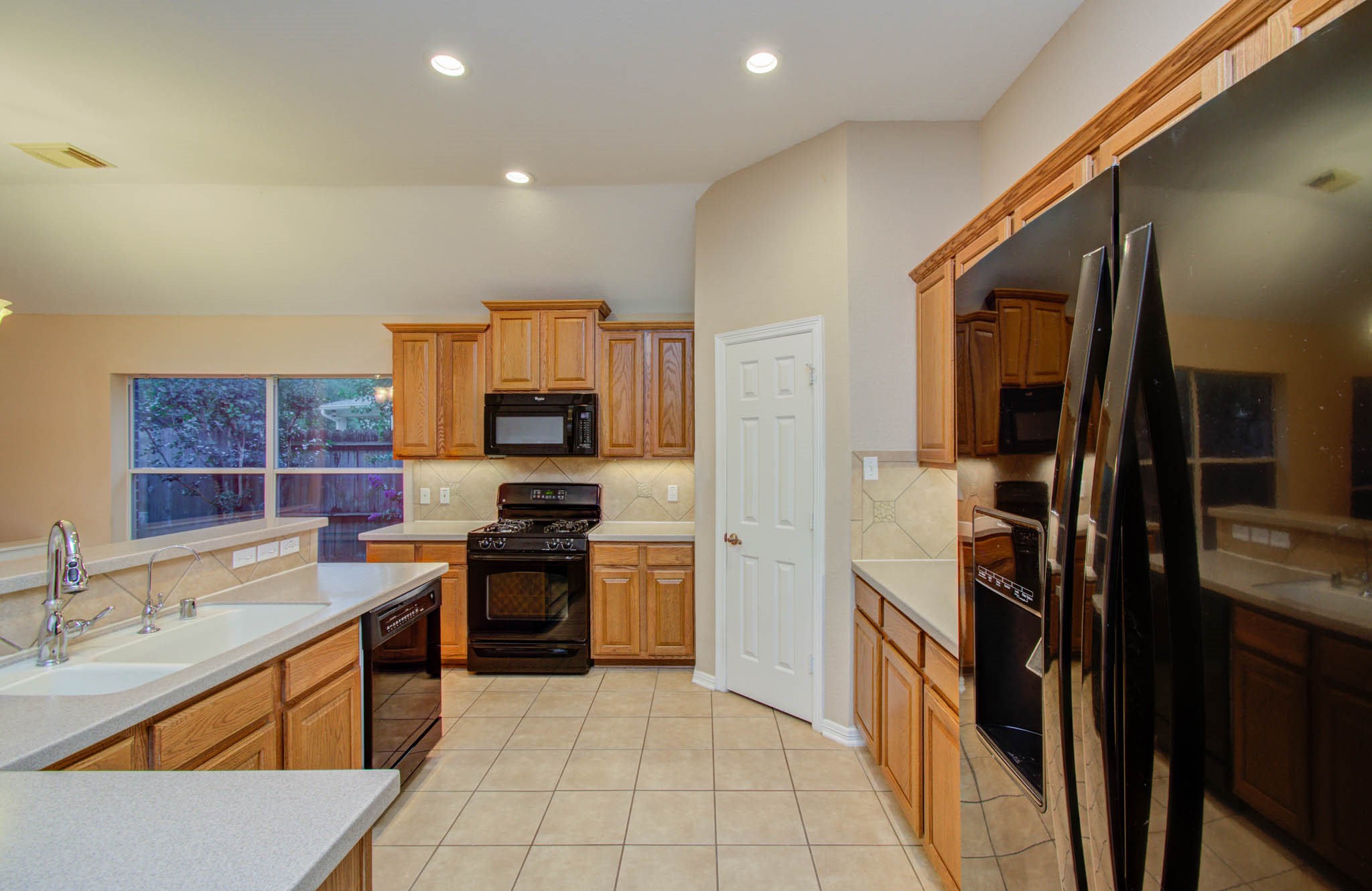 Spacious kitchen with modern appliances, warm wood cabinetry, and ample counter space, perfect for cooking and entertaining.