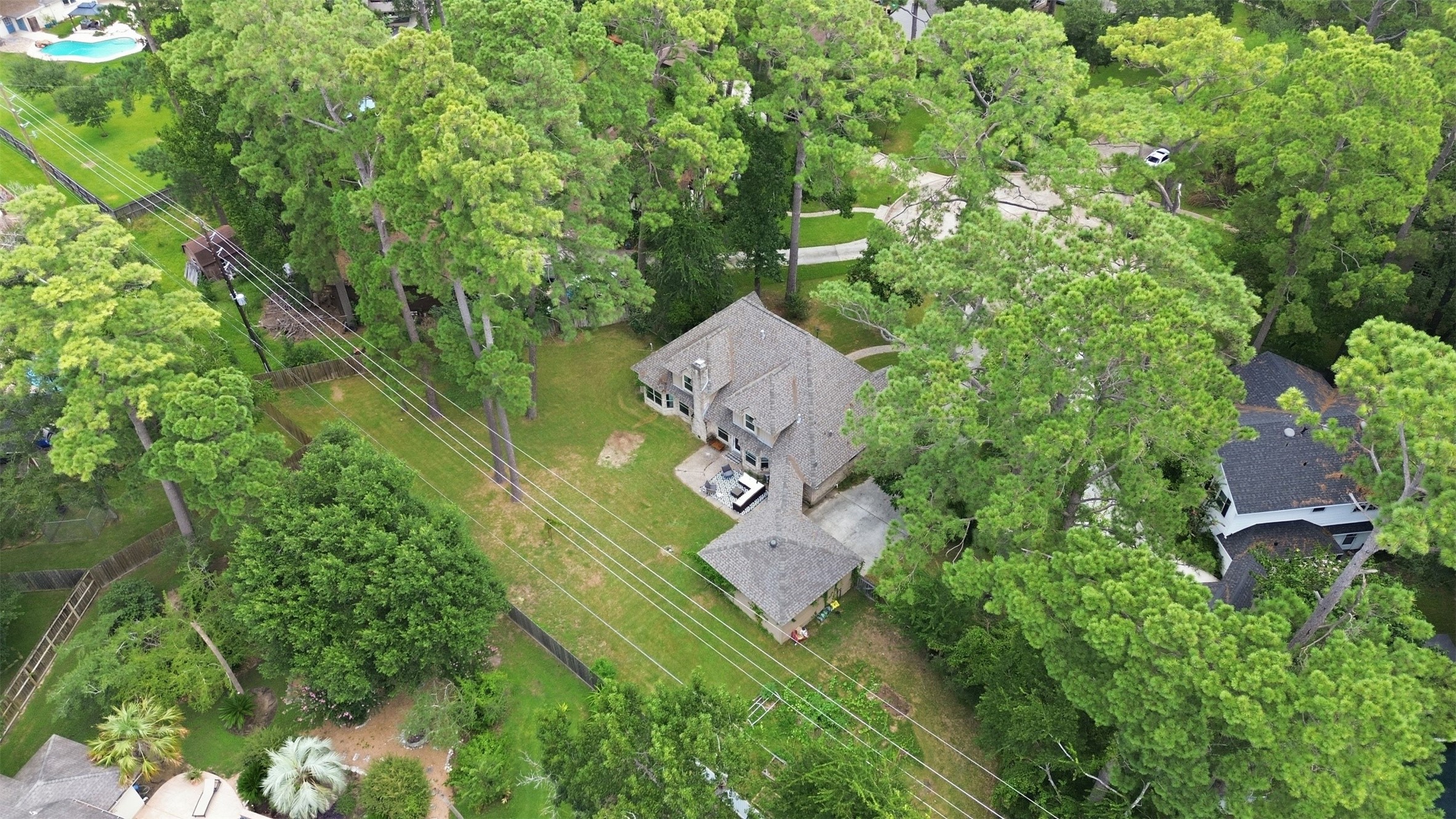 Aerial view showcasing the expansive, tree-filled lot with an impressive backyard and exceptional outdoor space.