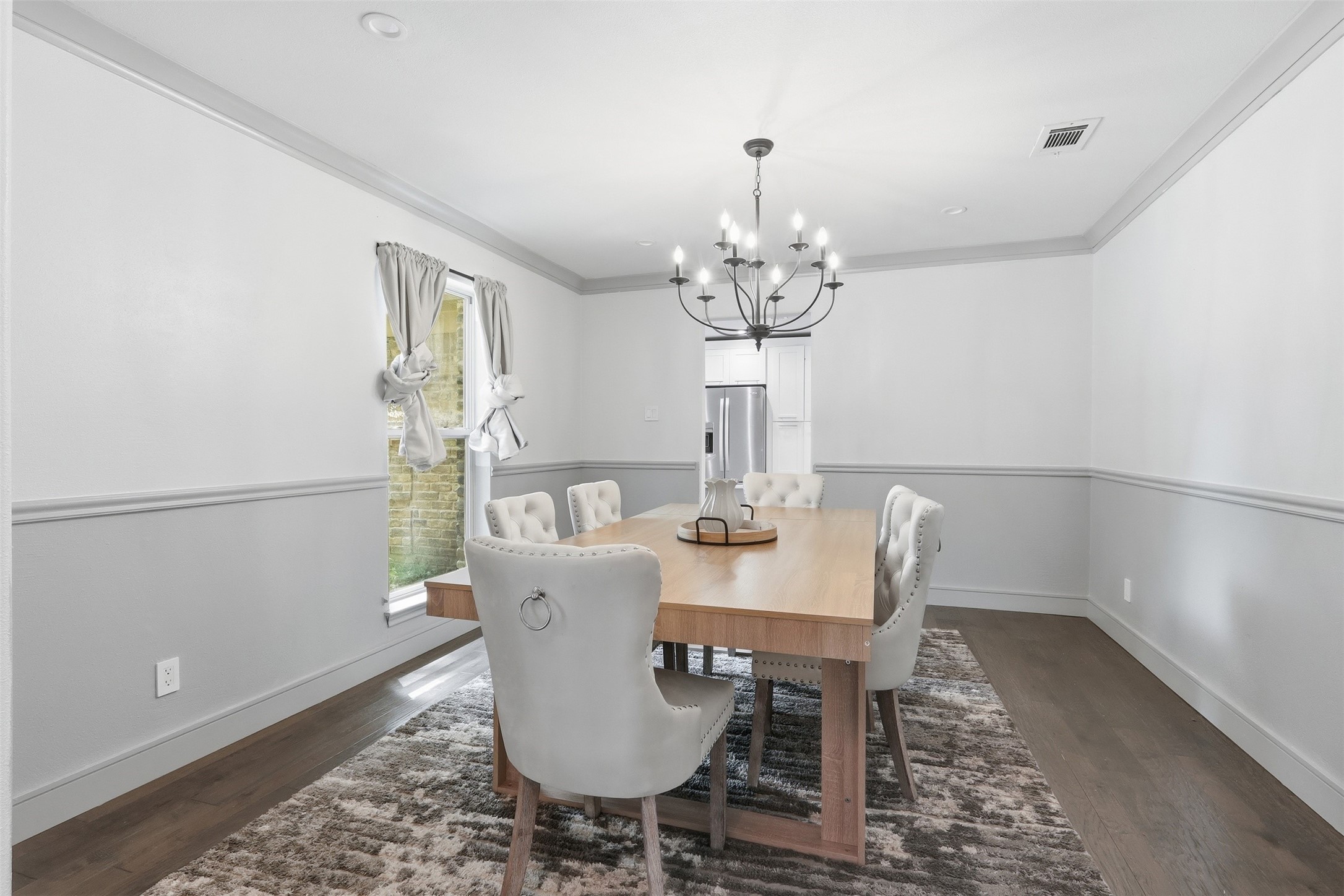 Elegant formal dining room with beautiful millwork, hardwood floors, and a statement chandelierperfect for hosting and gathering