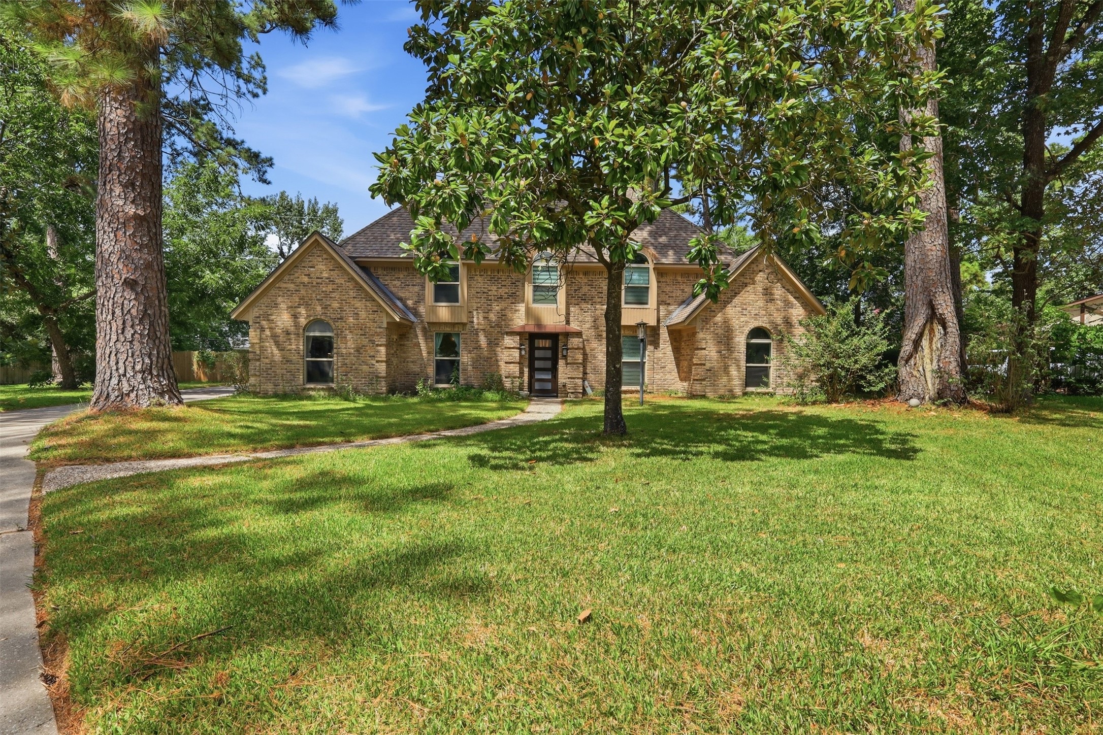 Beautifully shaded by mature trees, this stately brick home sits on an expansive lot with impressive curb appeal.