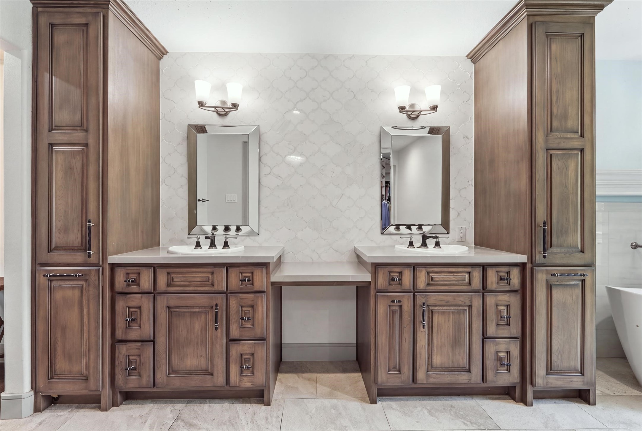 Beautifully appointed primary bath with dual vanities, custom cabinetry, abundant storage, and a dedicated vanity area.