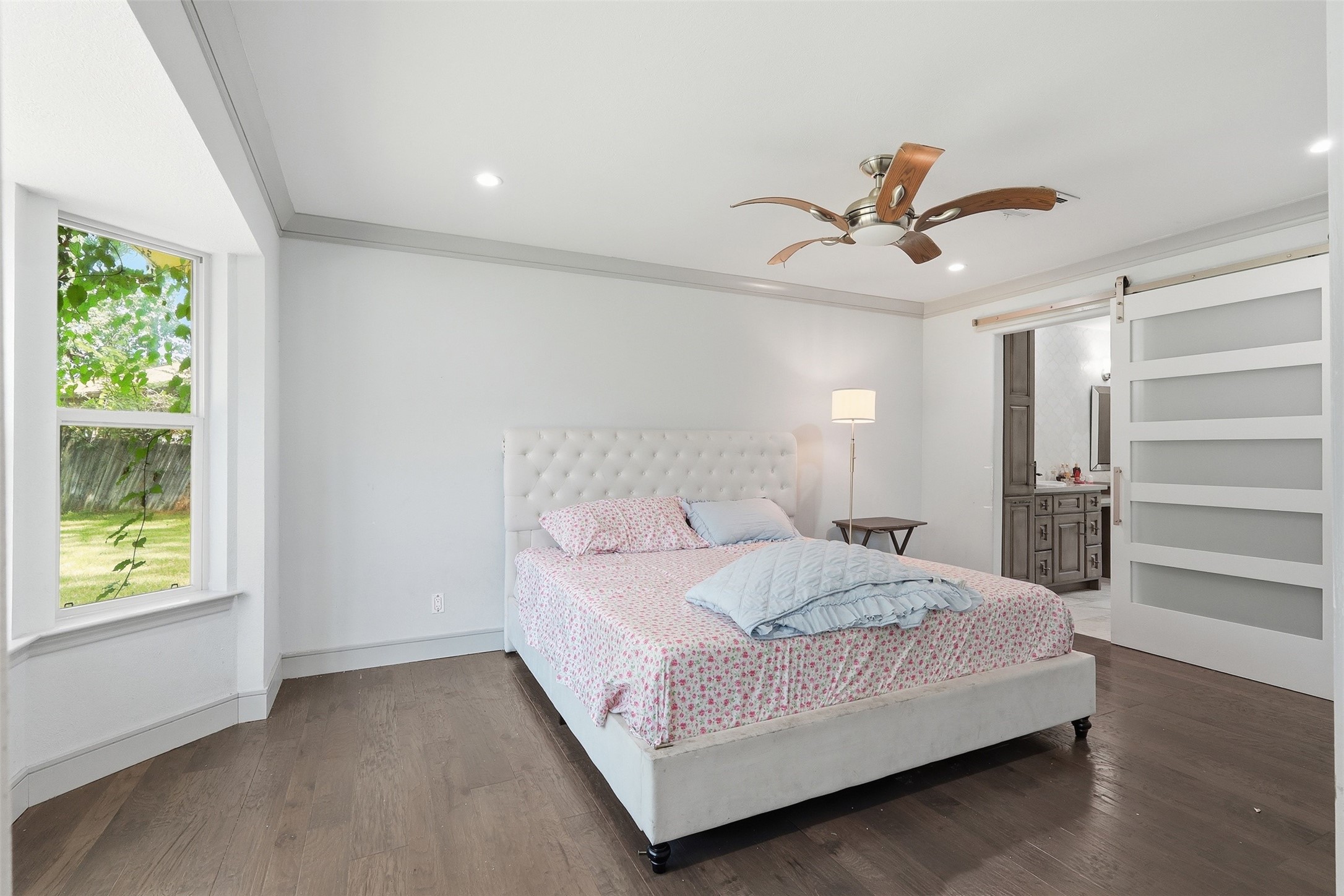Spacious primary suite with hardwood floors, abundant natural light, and private access to the en suite bath.