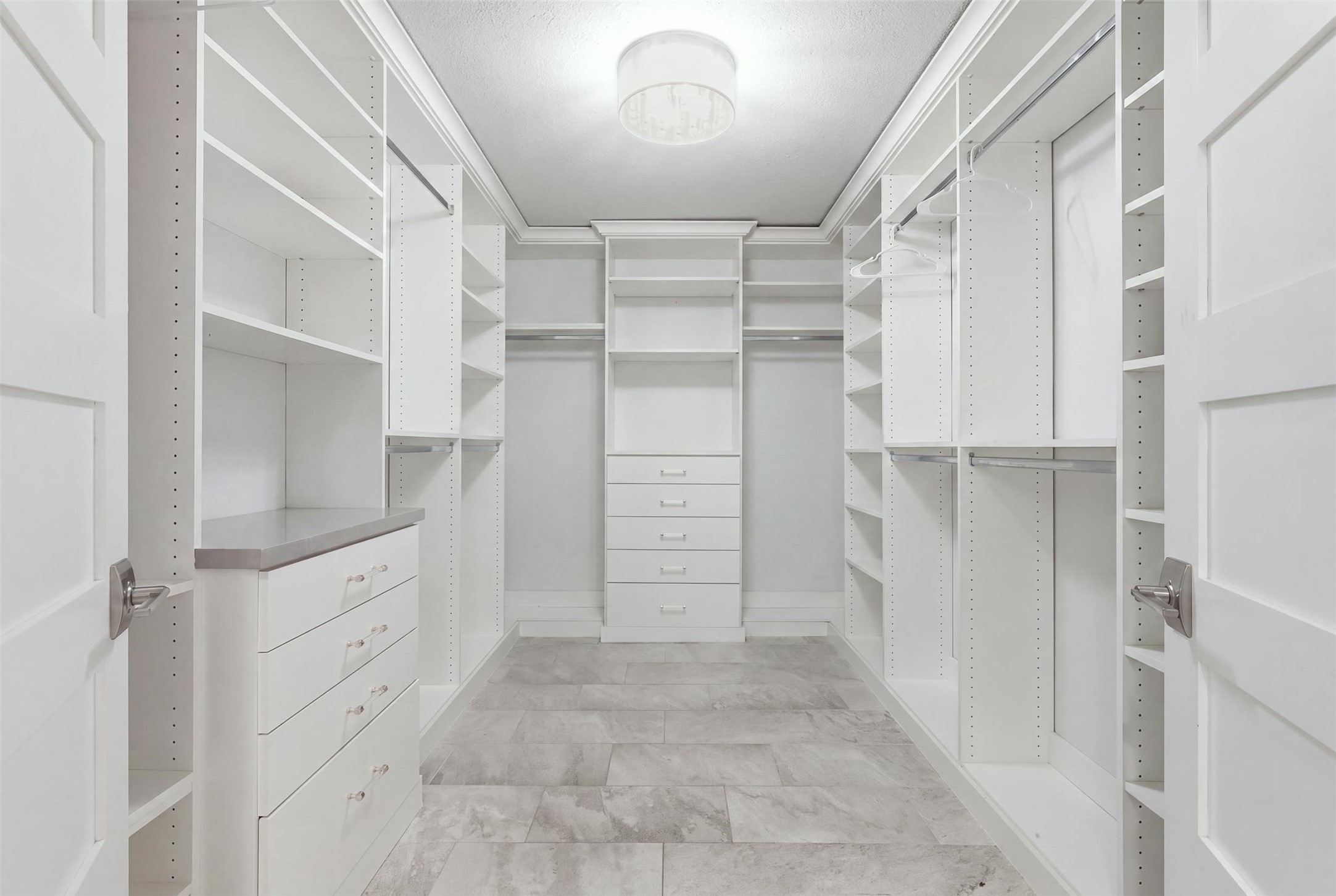 Dream-worthy walk-in closet with custom built-ins, abundant shelving, hanging space, and drawer storage.