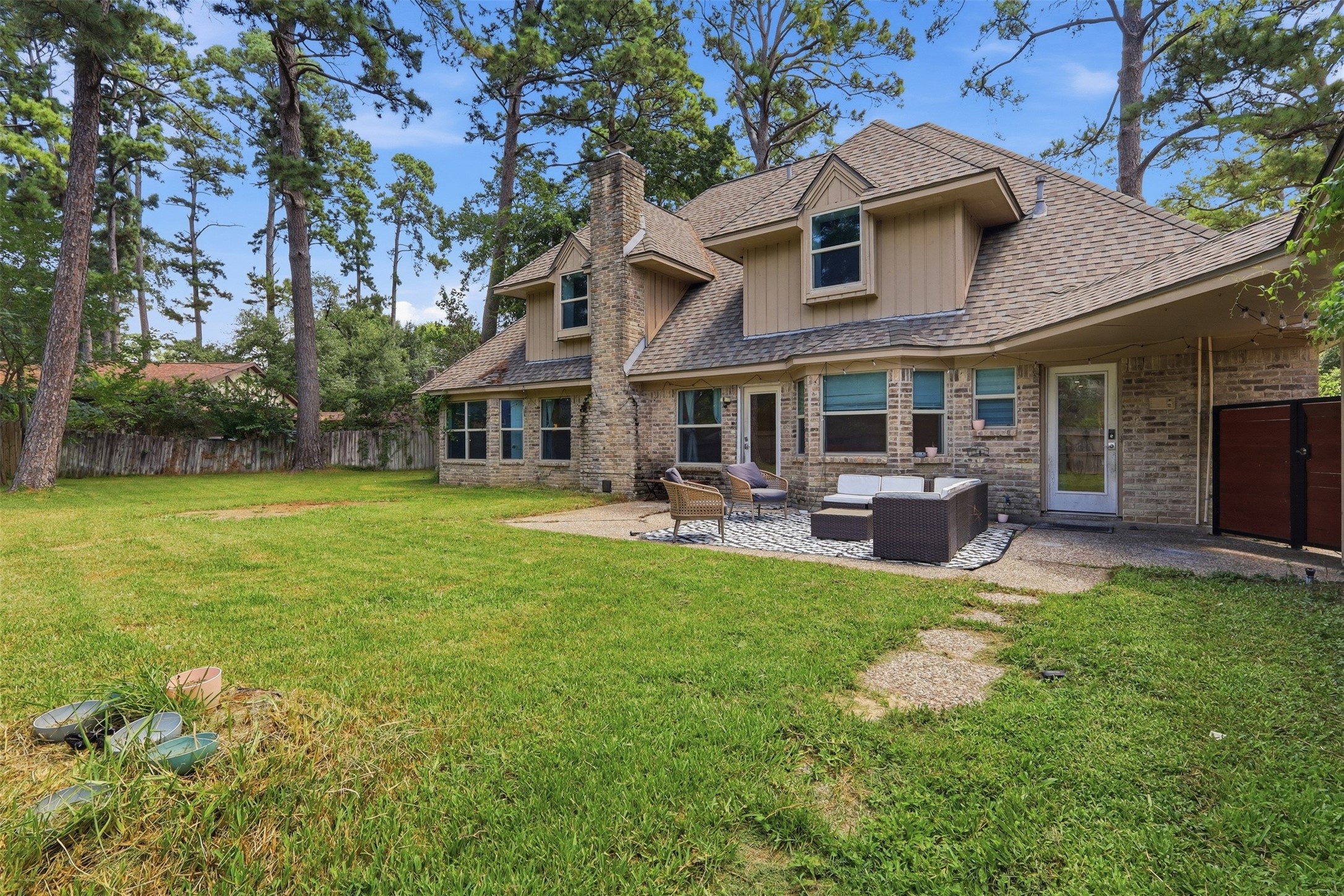 Expansive backyard surrounded by mature trees, offering incredible space to play, entertain, or create your dream outdoor retreat.