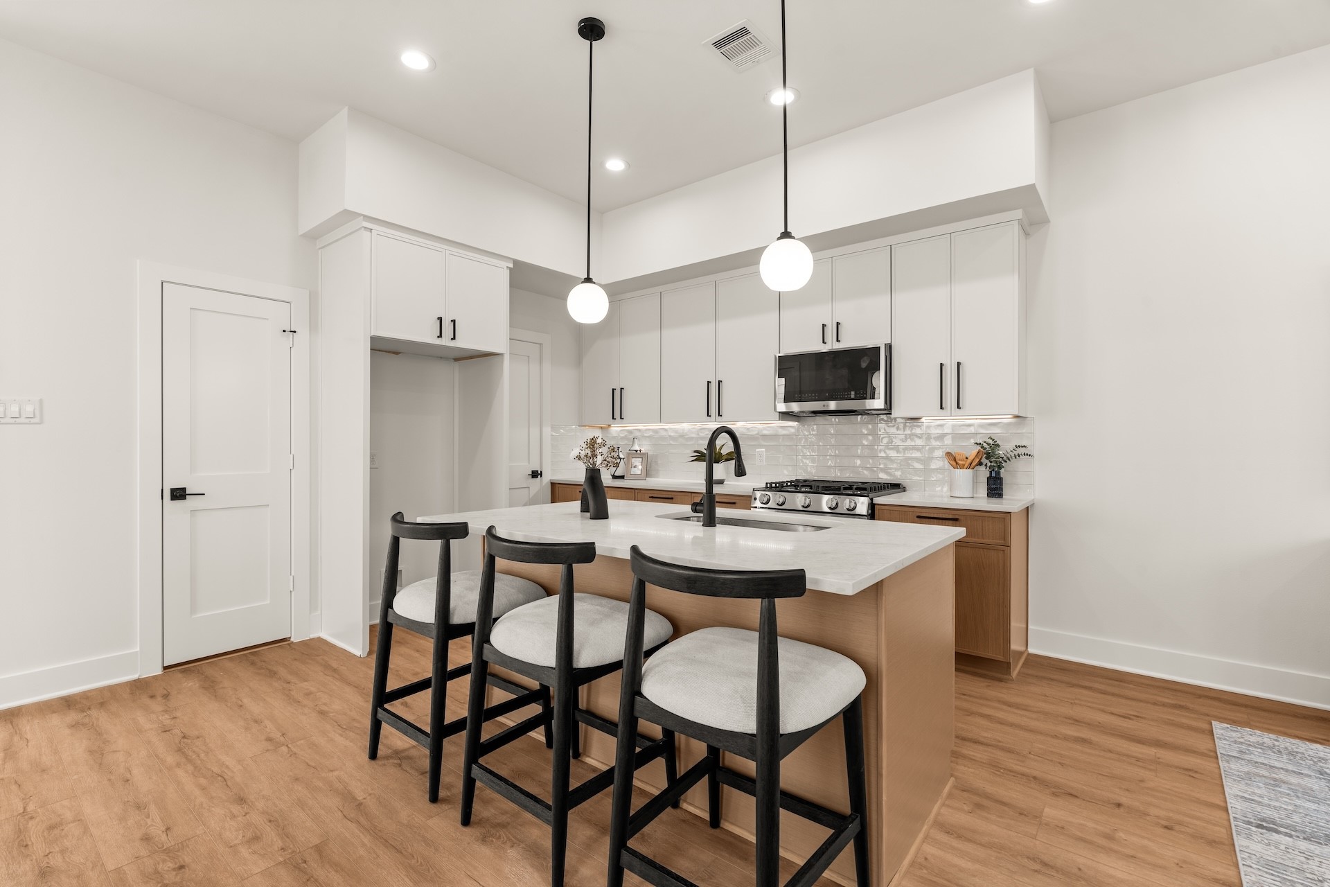 Gourmet kitchen equipped with two-tone cabinetry, quartz countertops, and island seating.