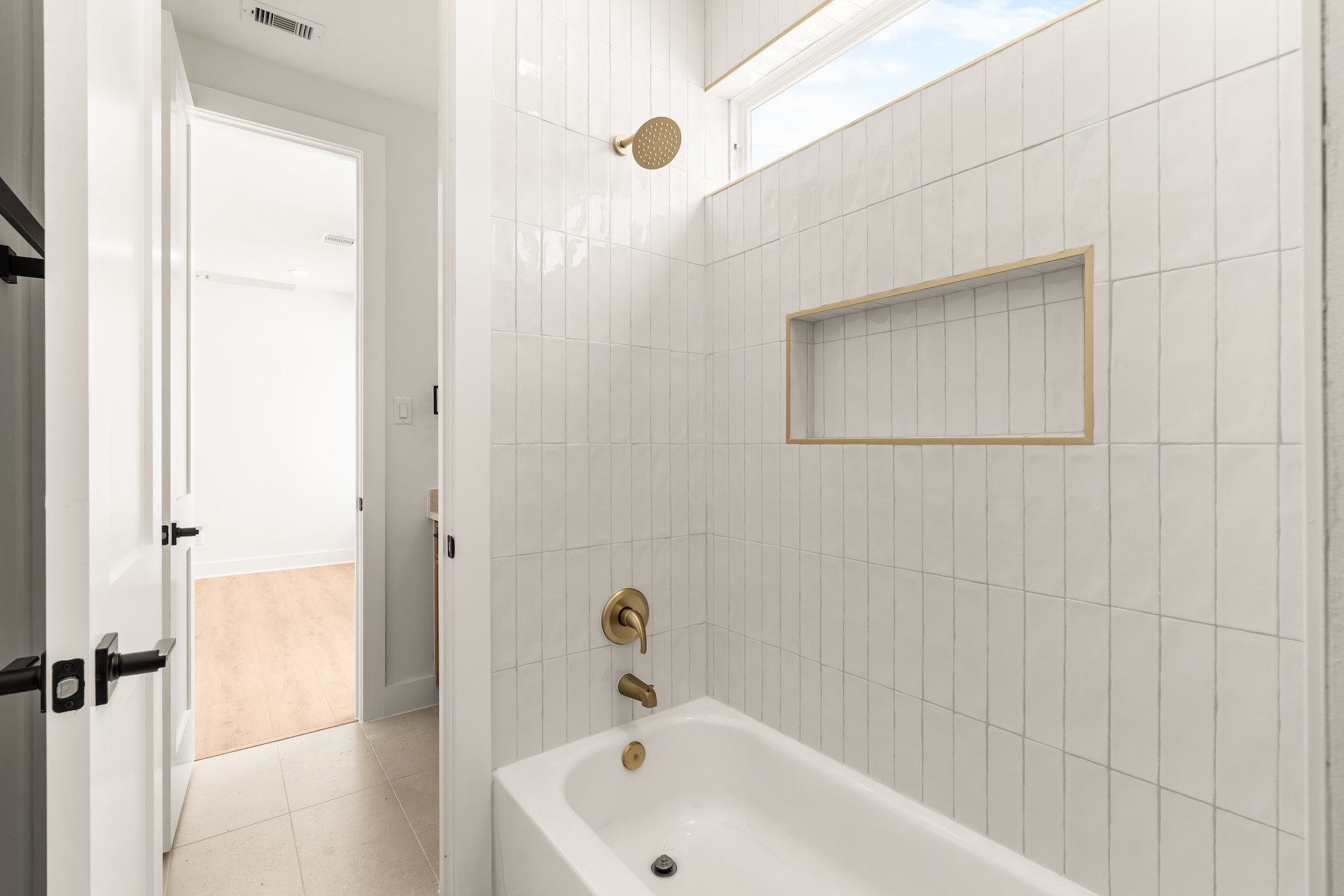 Refreshing secondary bath featuring a deep soaking tub and custom vertical tile surround.