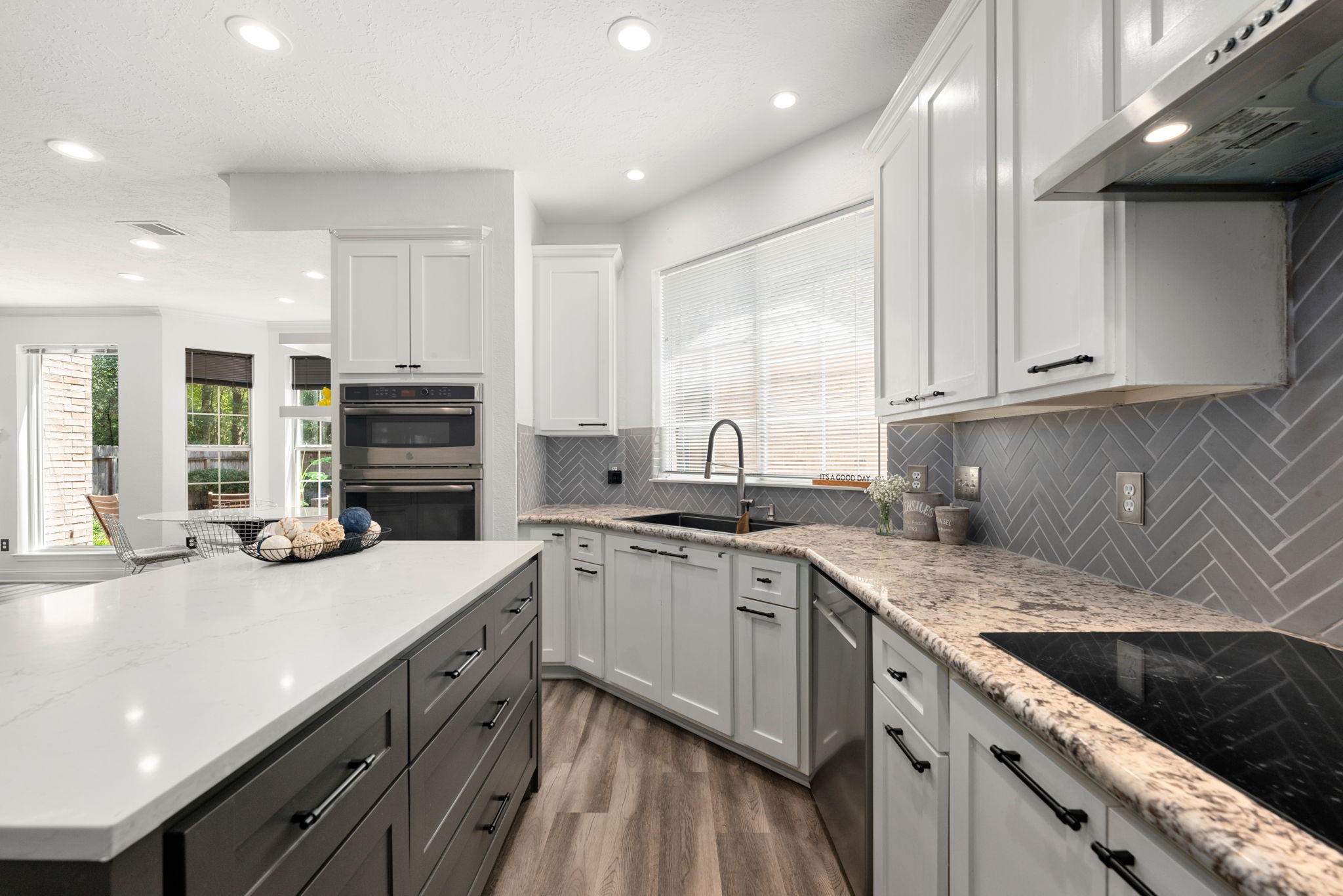 Modern kitchen featuring sleek white cabinetry, stainless steel appliances, and stylish island.