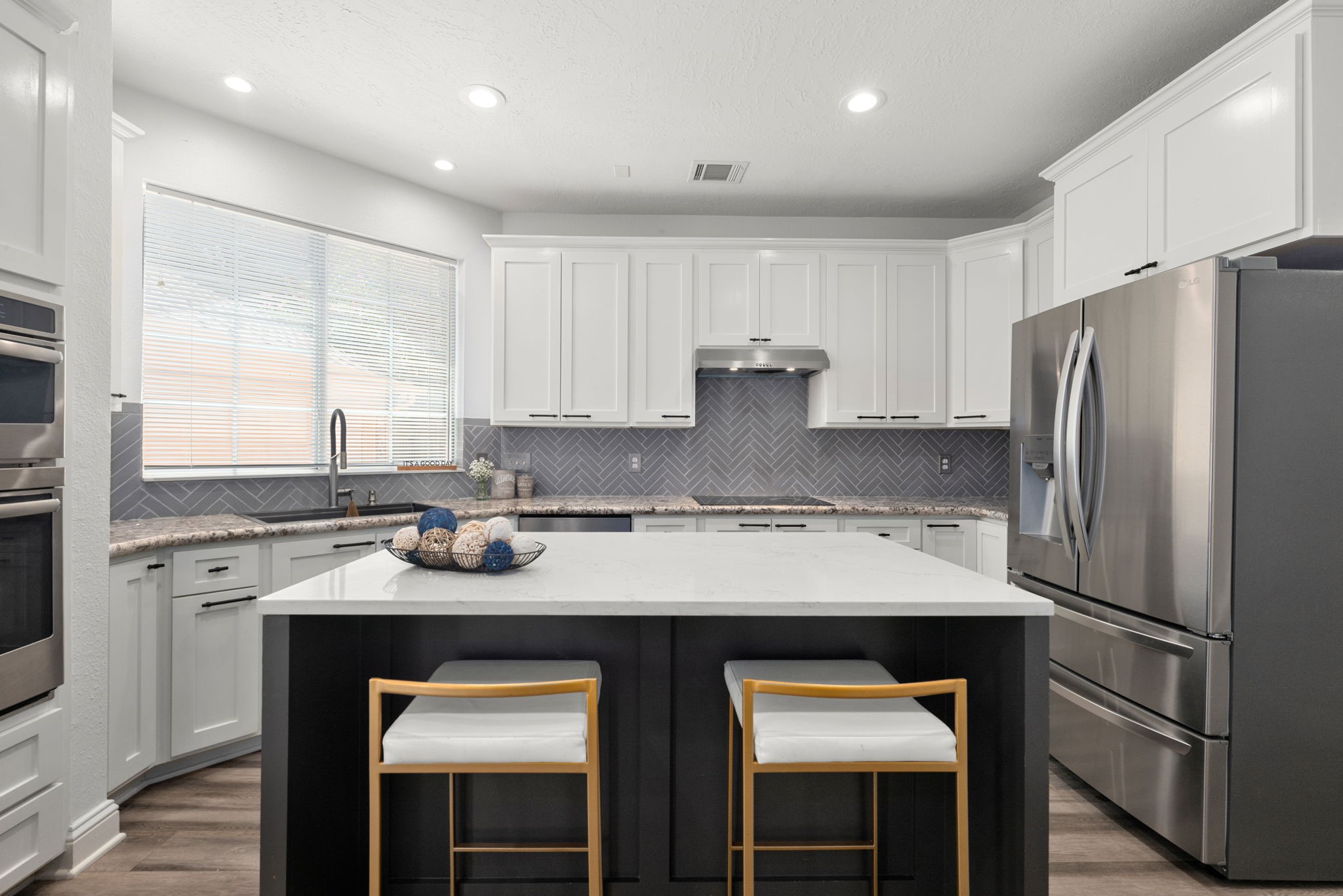 Modern kitchen featuring sleek white cabinetry, stainless steel appliances, and stylish island.