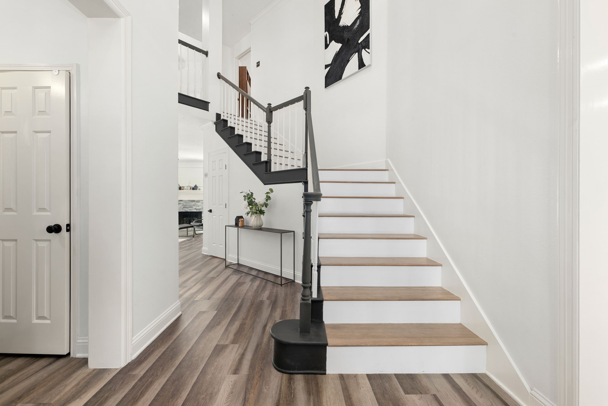 Elegabt entryway featurring a modern staircase with sleek black railing and light wood steps,