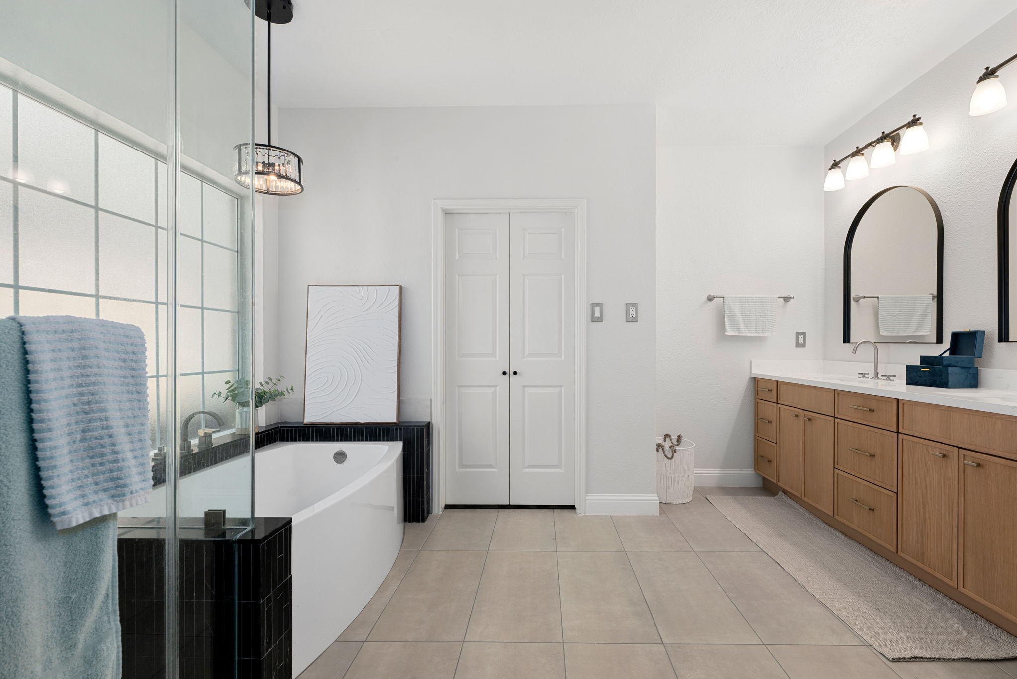 Enjoy a recently remodeled morden bathroom featuring a luxurios soaking tub, dual white oak vanities, stylish mirors.