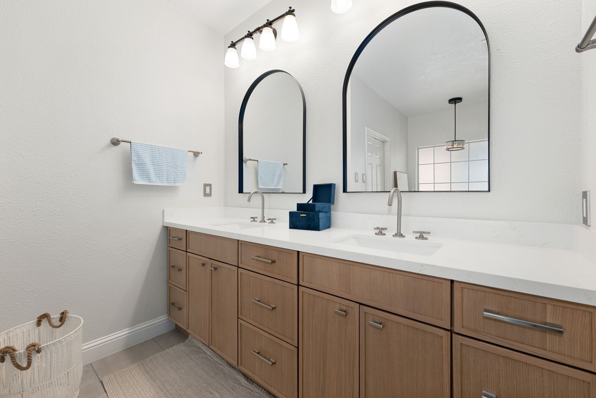 Elegant bathroom featuring a double vanity with sleek quartz countertop, modern fixtures.
