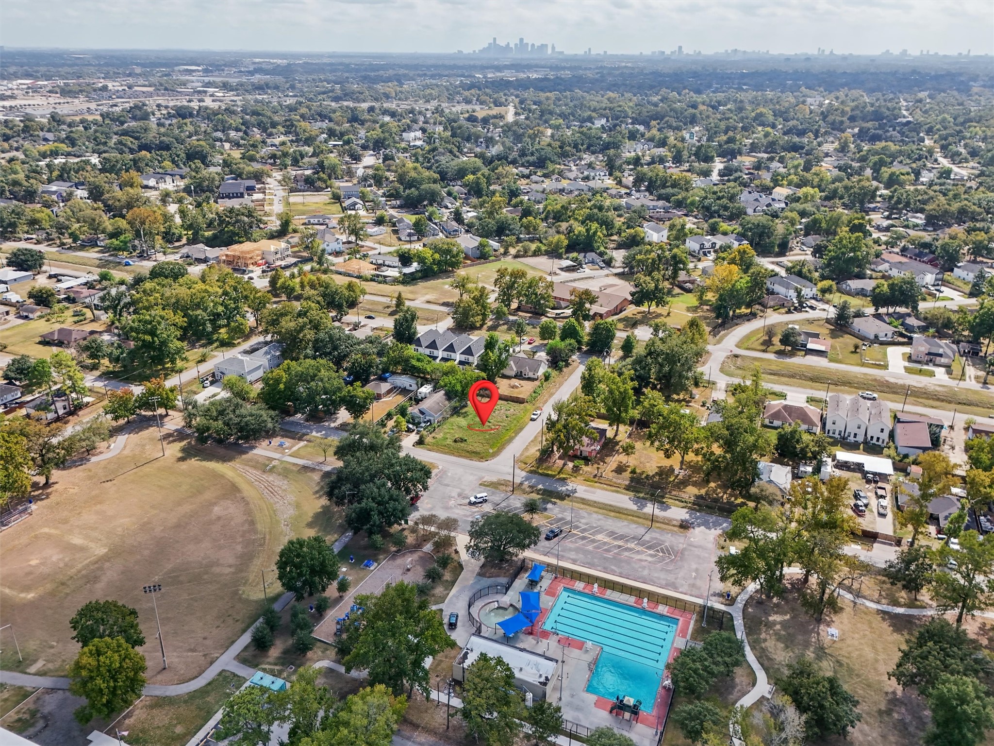 The Houston skyline is visible in the distance, showcasing the property's setting within the greater Houston area. A wonderful opportunity to build your dream home with recreational amenities just across the street!