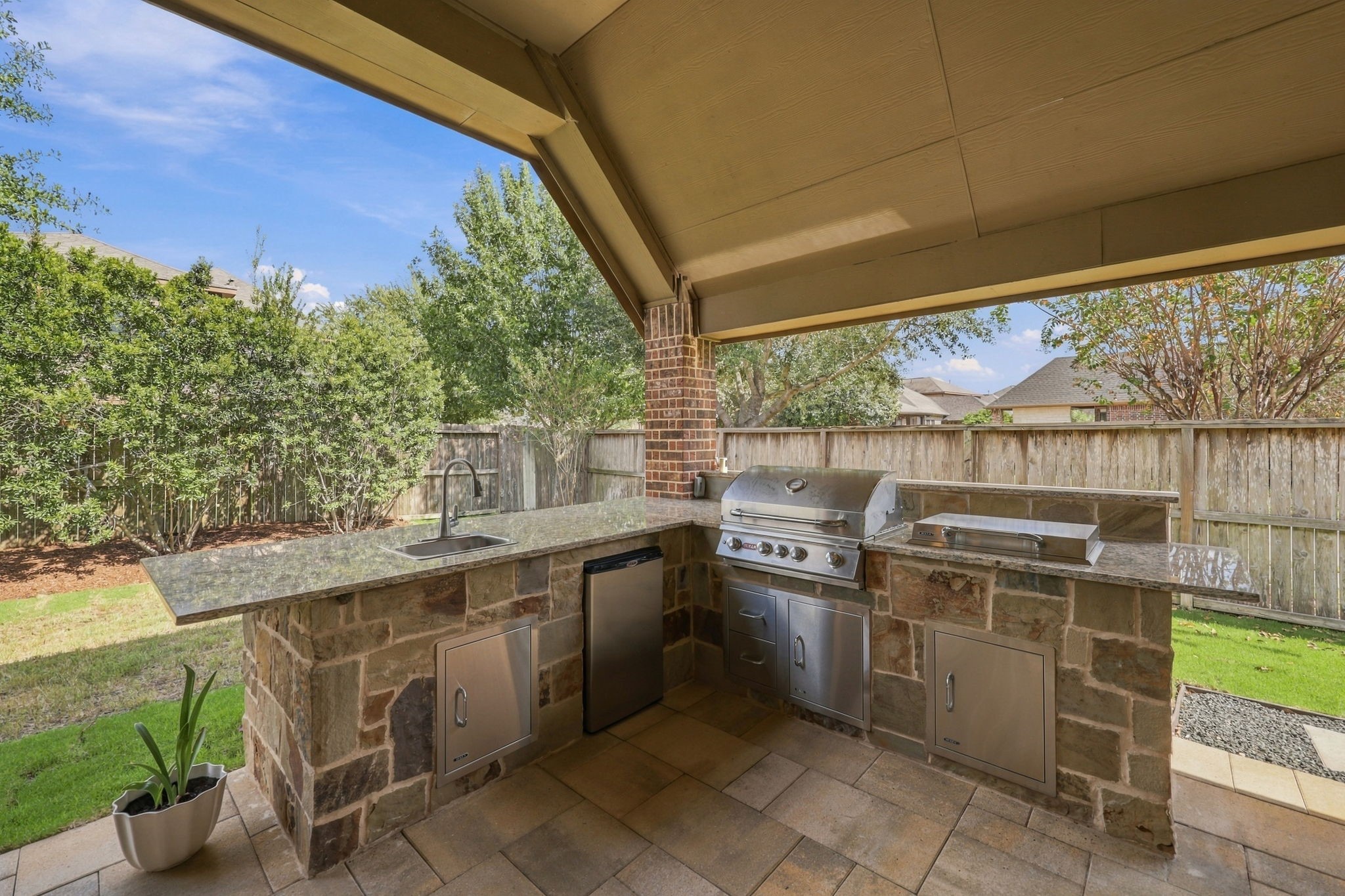 Added in 2021, the built-in Summer Kitchen is perfect for outdoor cooking and entertaining. It features a Bull stainless steel grill with storage below, a convenient side burner, and a beverage refrigerator. Granite countertops provide ample workspace, while the stainless steel undermount sink with a gooseneck faucet adds functionality. Beautiful stone accents complete this impressive outdoor kitchen, creating an inviting space for hosting family and friends.