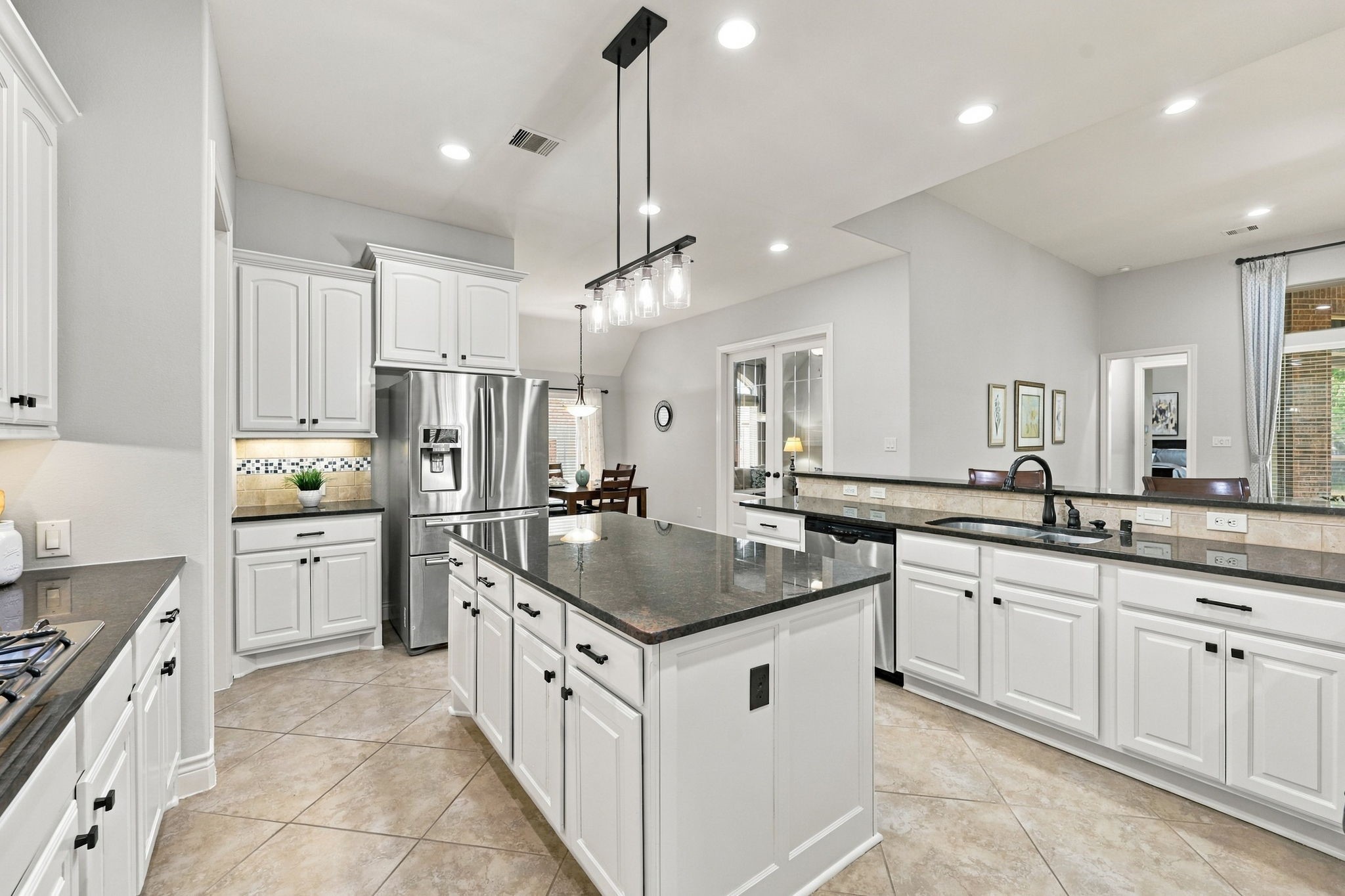 The spacious Kitchen is a chef's delight, featuring abundant gorgeous granite countertops, crisp white cabinetry, and a large center island that provides additional workspace and a natural gathering spot. With plenty of room for meal preparation and entertaining, this kitchen combines timeless style with everyday functionality.