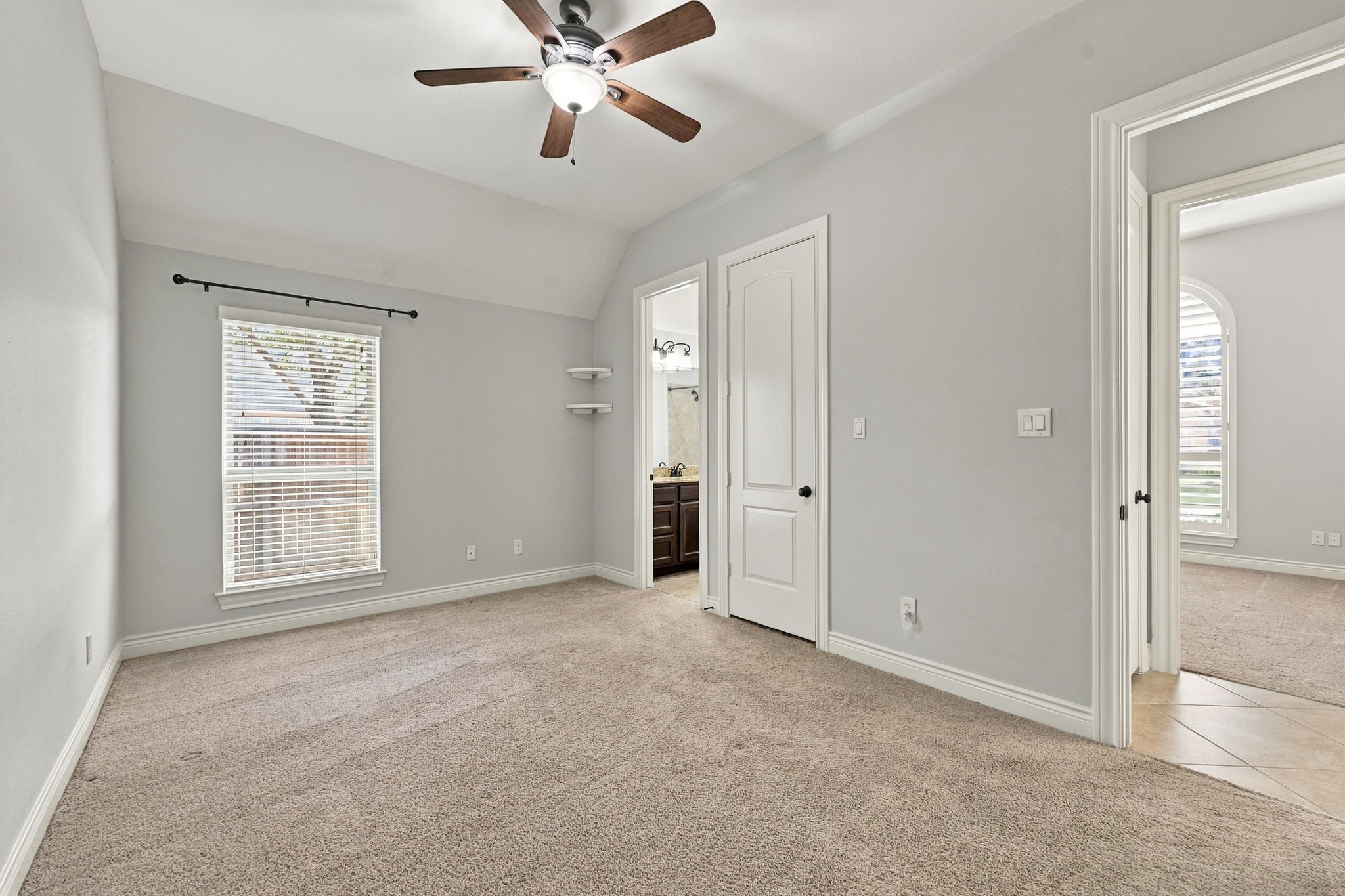 Bedroom #3 features a large window with 2-inch blinds, allowing natural light to fill the space while providing privacy. This generously sized Bedroom also offers a walk-in closet and direct access to the Full Bathroom shown in the previous photo, providing added convenience and functionality.
