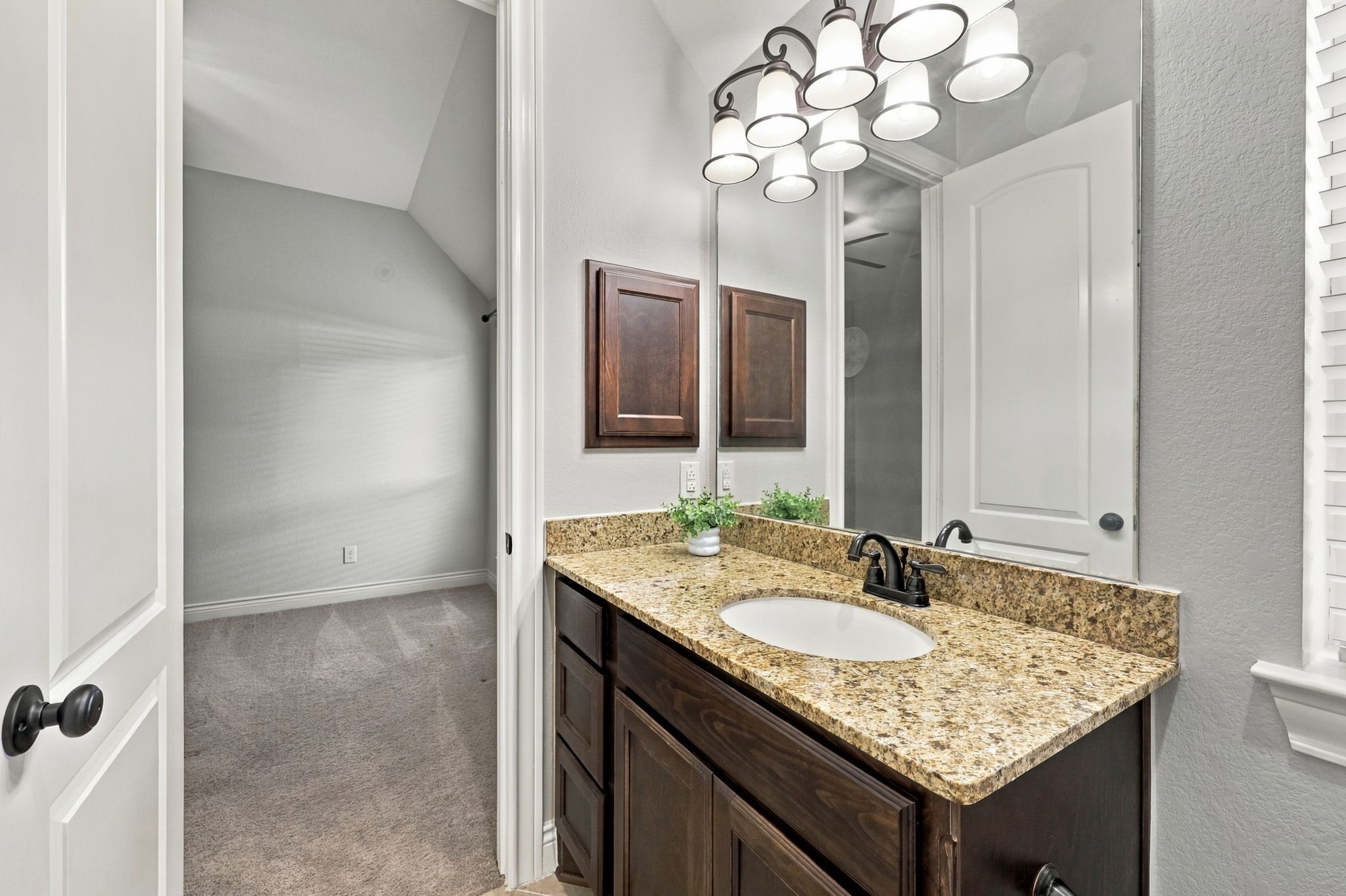 This closer look at the vanity area highlights the Full Bathroom shared by Bedrooms #2 and #3. Features include an undermount sink, a convenient medicine cabinet, and beautiful espresso cabinetry and drawer storage, combining style and functionality.