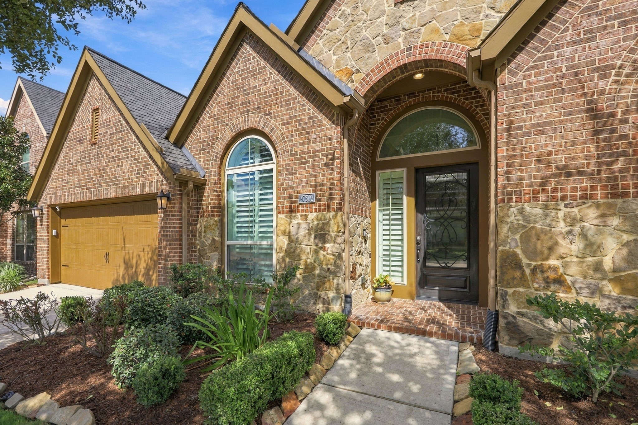 As you make your way to the front entrance, you'll notice the beautifully landscaped beds bordered with stone, adding a polished touch to the home's exterior. The inviting arched, covered front porch features charming brick accents and brick flooring, creating a warm and welcoming entry. As you make your way to the front entrance, you'll notice the beautifully landscaped beds bordered with stone, adding a polished touch to the home's exterior. The inviting arched, covered front porch features charming brick accents and brick flooring, creating a warm and welcoming entry.