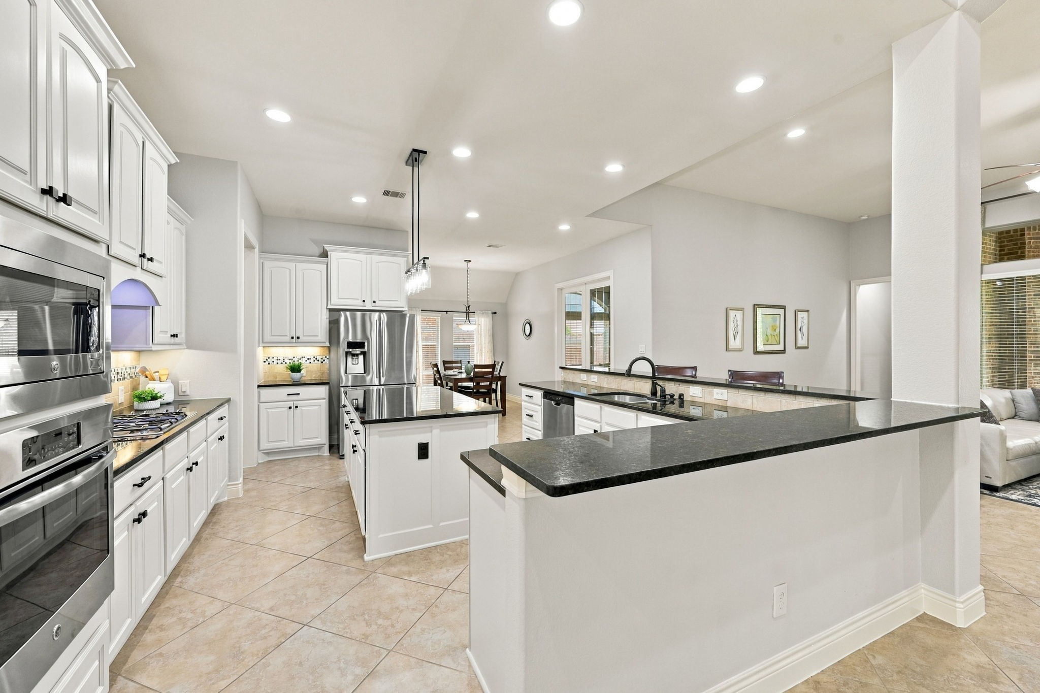 This view further highlights the generous size of the Kitchen, offering plenty of room to cook, gather, and entertain. The L-shaped Breakfast Bar provides additional seating for six to seven people, making it an ideal spot for casual meals, morning coffee, or visiting with family and friends while preparing meals.