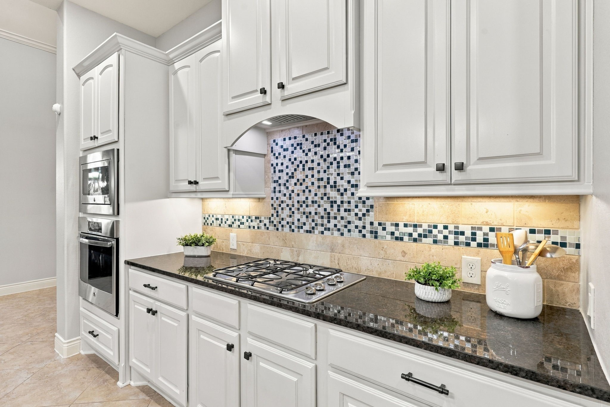 The Kitchen is equipped with GE stainless steel appliances, including a 4-burner gas cooktop, microwave, dishwasher and electric oven, offering a functional setup for everyday cooking and entertaining.