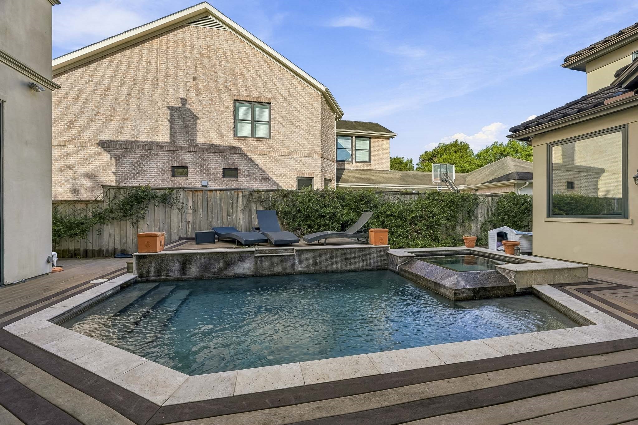 Experience luxury outdoor living with this stylish pool area, featuring a modern design, relaxing sun loungers, and a serene water feature, perfect for entertaining or unwinding.