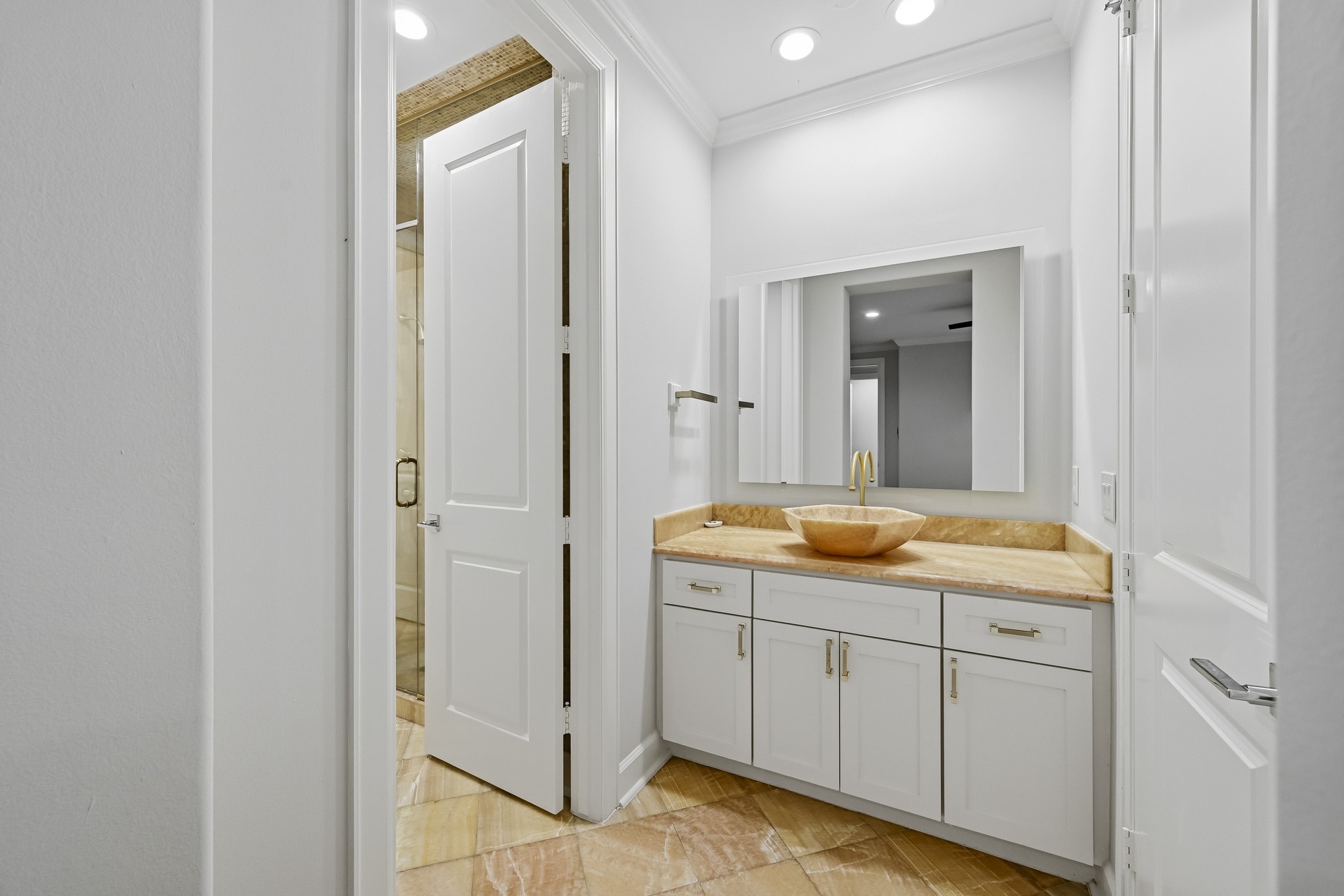 Elegant jack and jill bathroom featuring a stylish vessel sink atop a sleek vanity, complemented by modern fixtures and ample lighting.