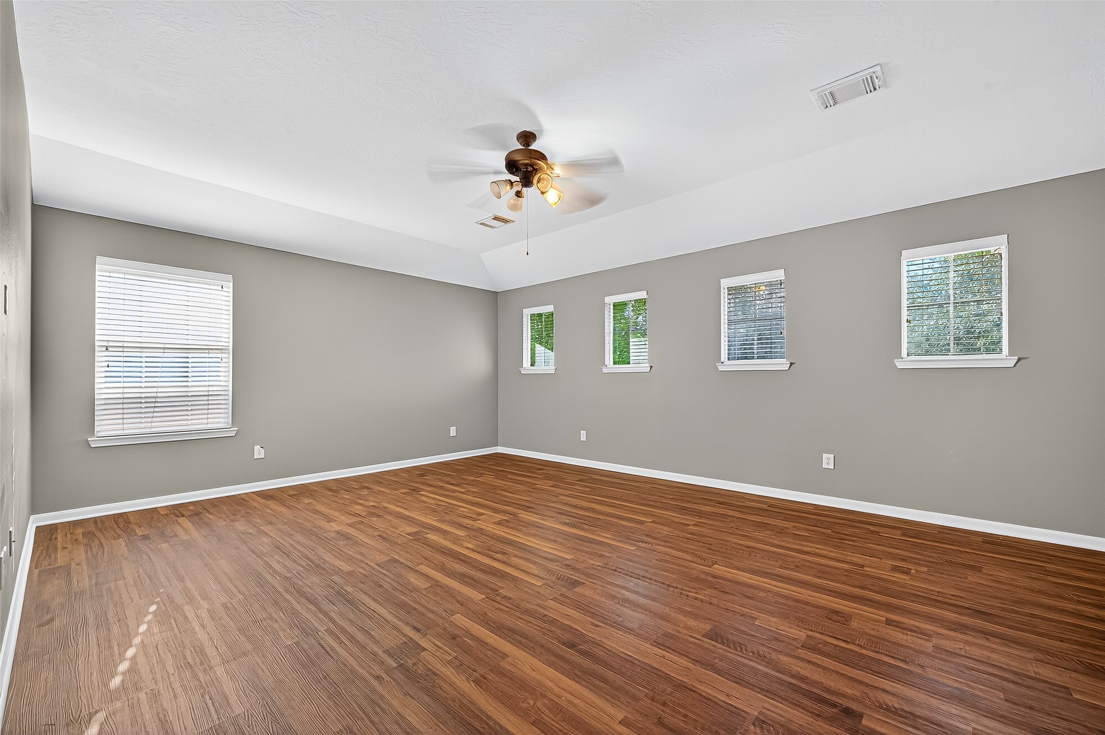 Bright and open gameroom offers new flooring and plenty of windows for natural light.