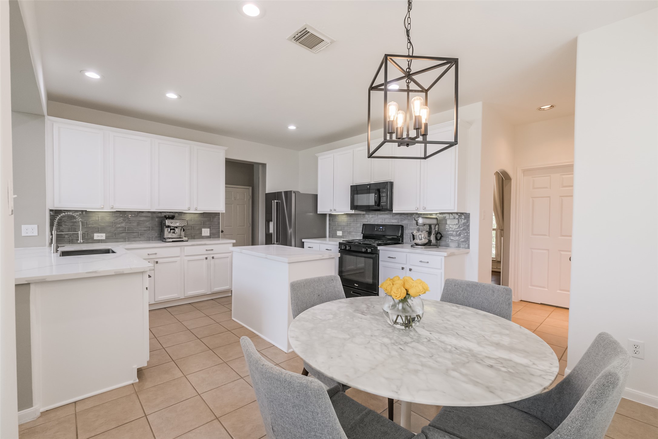 This photo showcases a modern kitchen with white cabinetry.