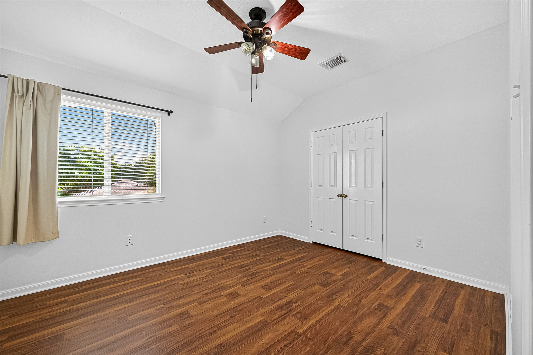 Bright and cozy bedroom 4 with a ceiling fan, featuring a large window, and NEW FLOORING!