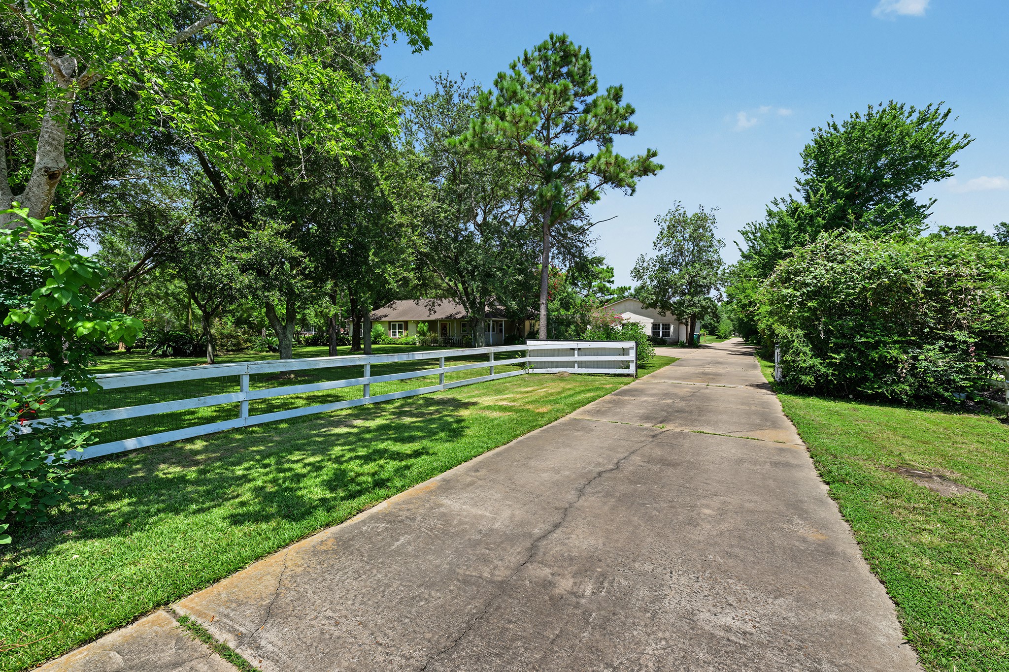 Fenced motorized entry gate and white picket fence