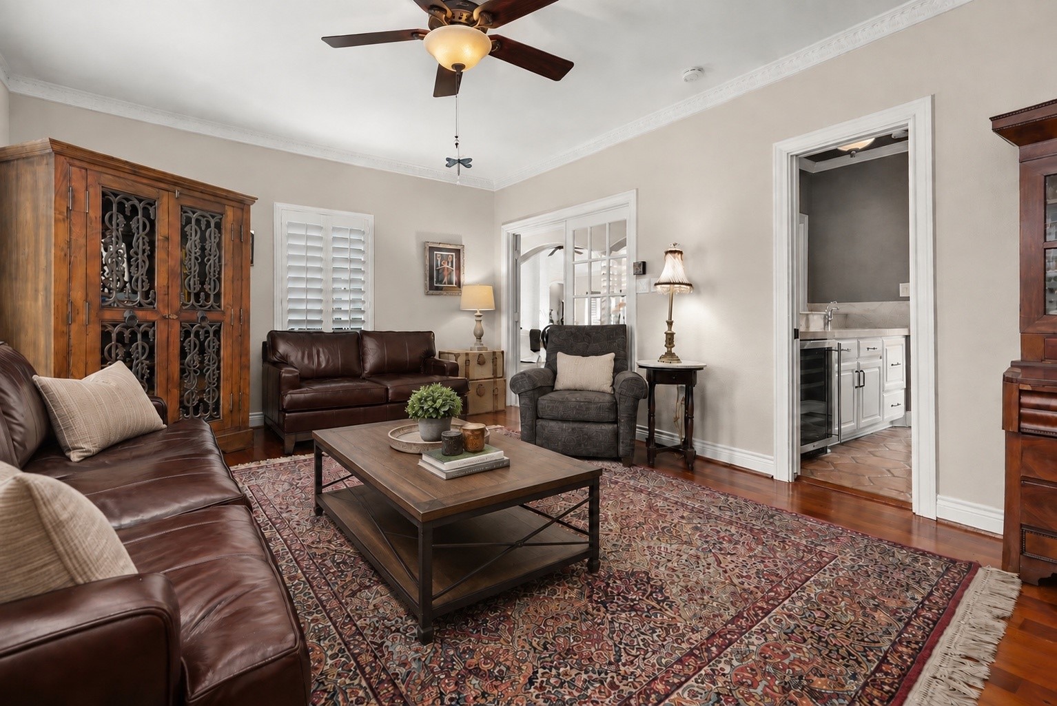 Currently used as a cozy television room, this versatile space features beautiful solid mesquite wood flooring brought in from Austin, plantation shutters, and a convenient walk-through wet bar connecting to the kitchen. Located just off the entryway near the dining area.